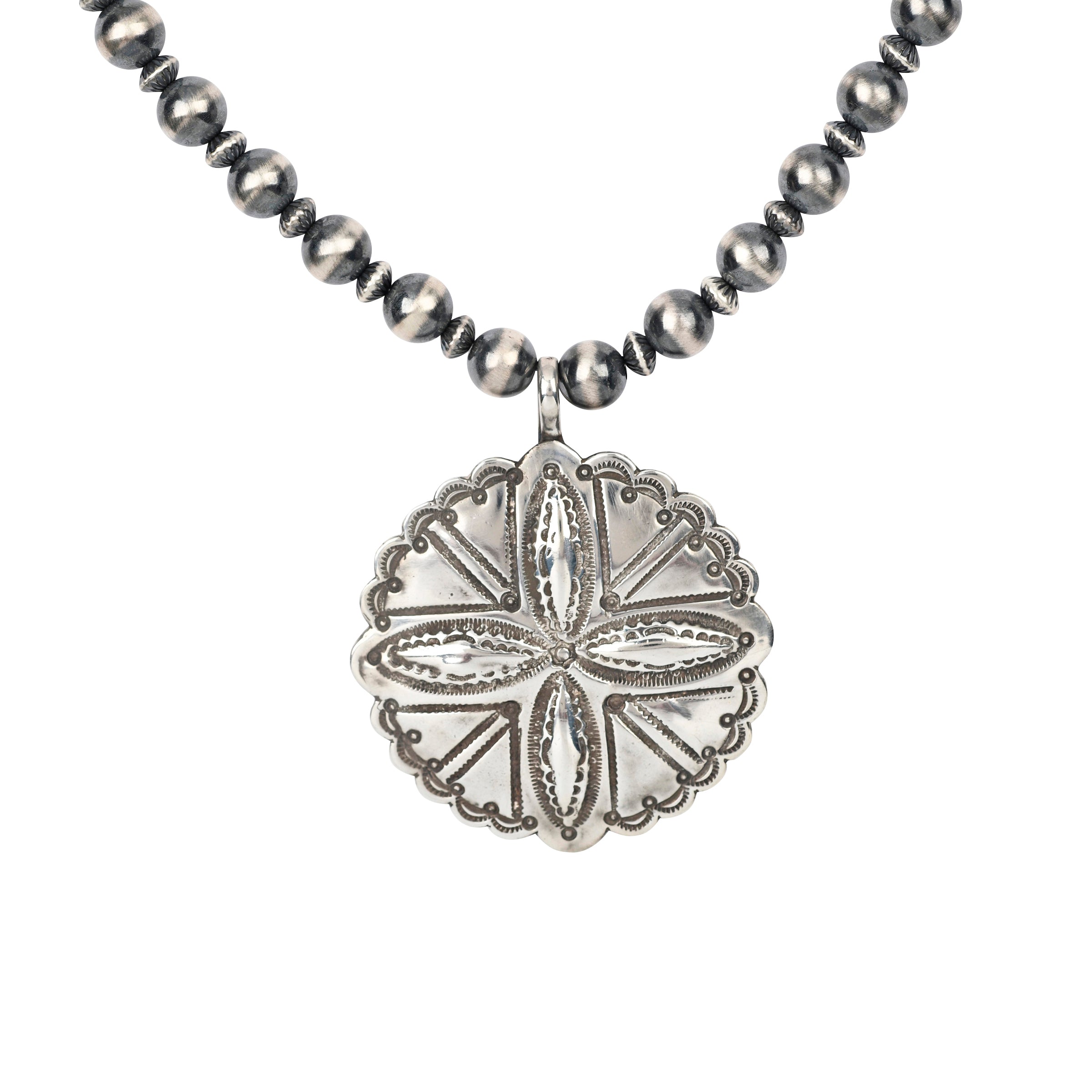 The Tierra Necklace features a large concho-style pendant with Southwestern motif stamping strung on a strand of Desert Pearls. Pendant made by Buffalo. This piece was showcased in the Sundance Catalog.