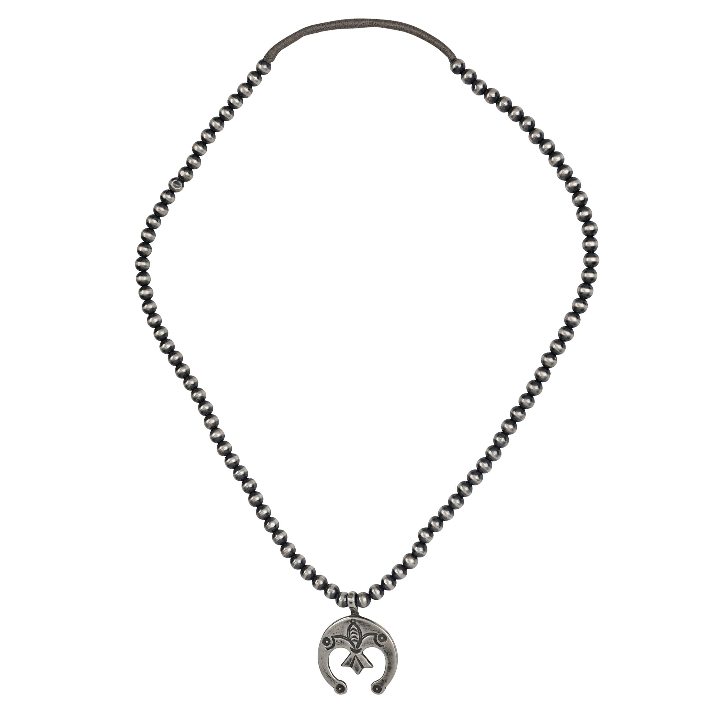 A Sterling Silver stamped Naja Pendant strung on a string of Desert Pearls. Features Santa Fe Style motifs and is long enough to be layered with your other favorite pieces.