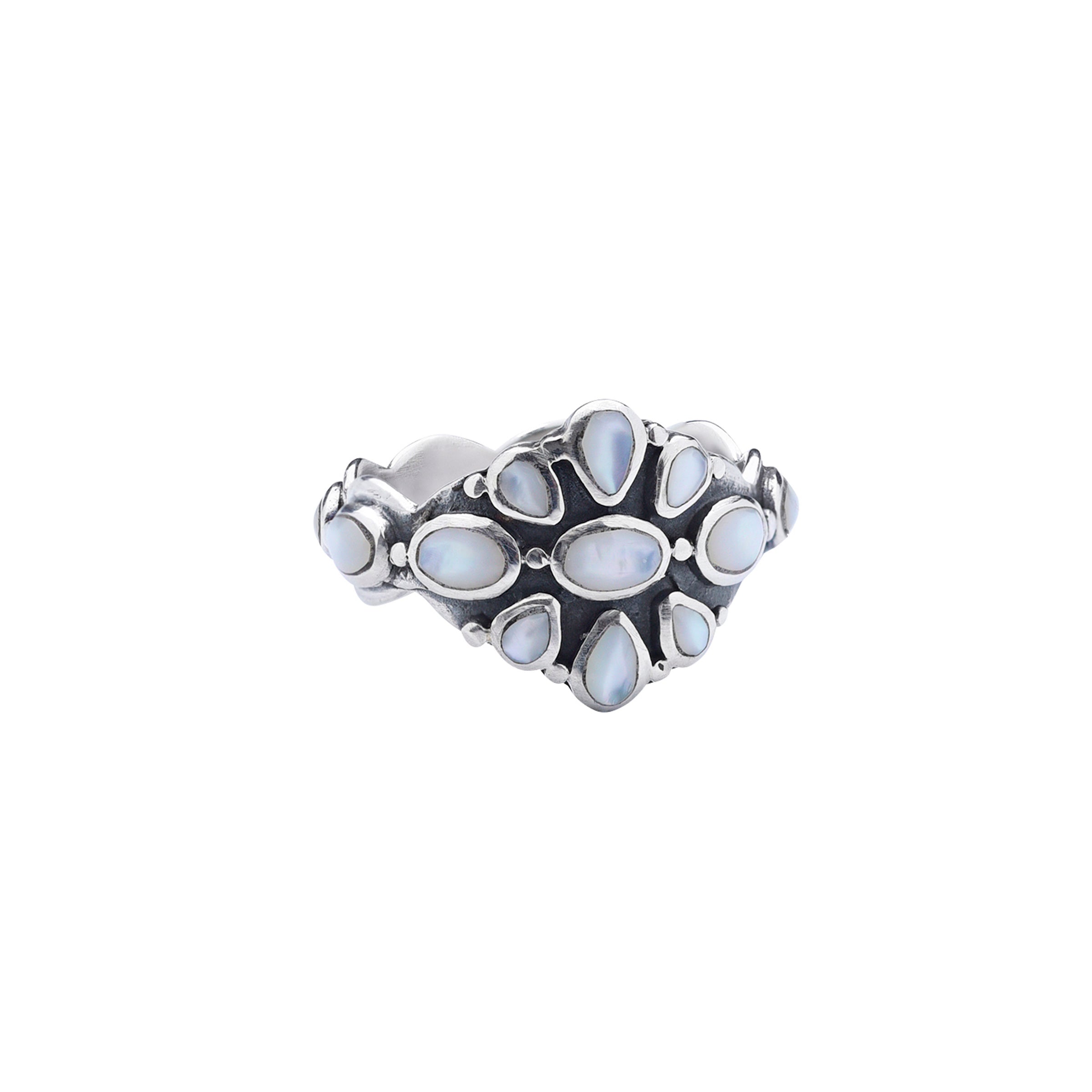 A Sterling Silver floral statement ring inlayed with Mother of Pearl Shell. The band of this ring is also inlayed with Mother of Pearl the whole way around.