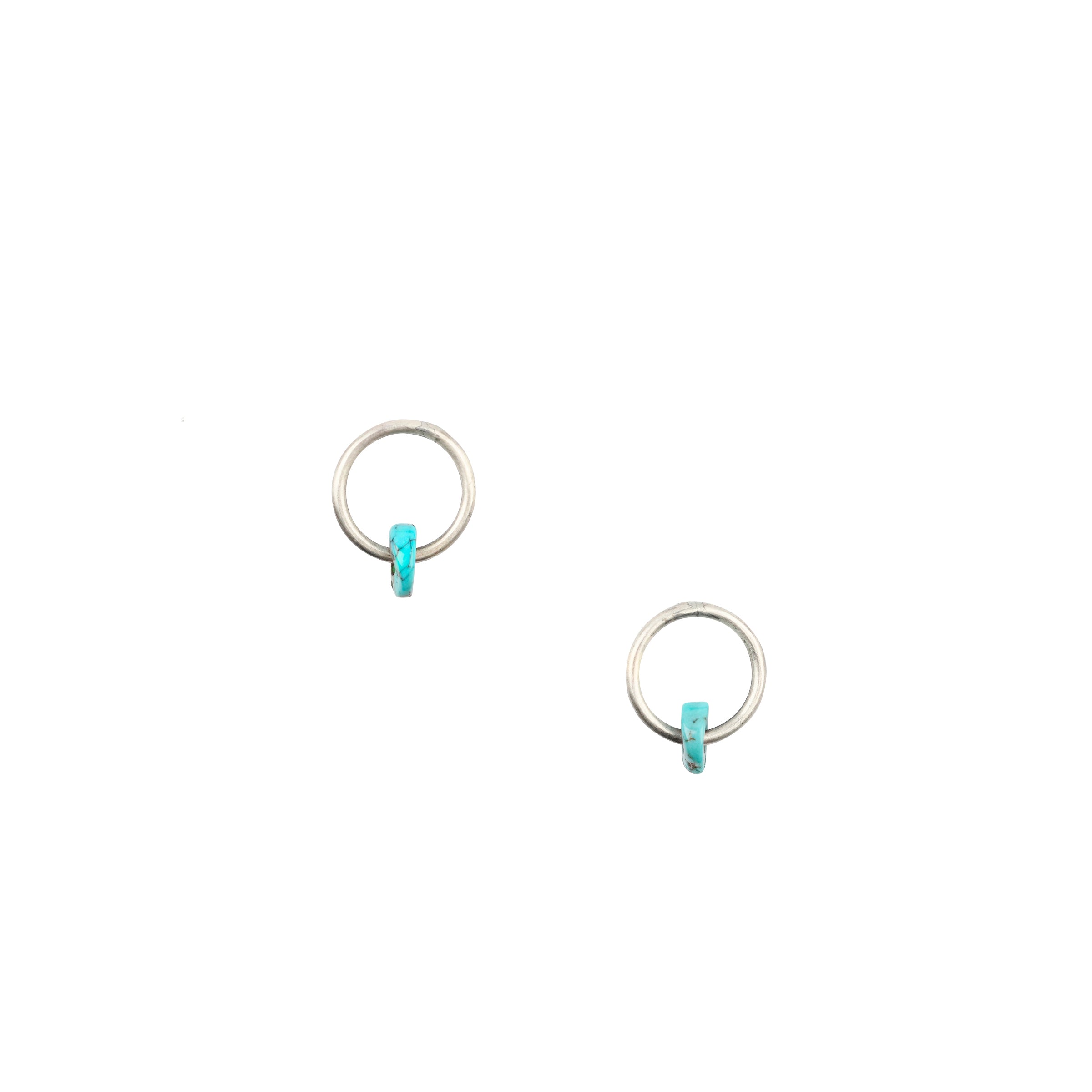 As seen in the Sundance Catalog, the In the Circle Earrings are stud earrings featuring Sterling Silver hoops with a single Blue Turquoise disc bead.