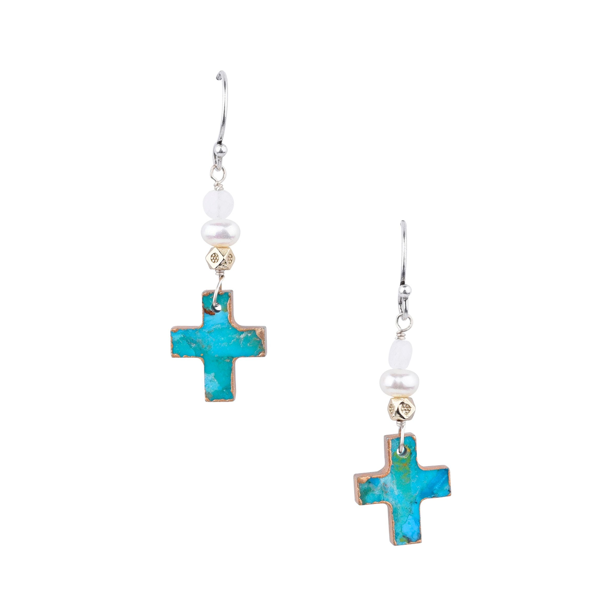 A pair of earrings featuring a turquoise cross design with silver and gold accents, attached to white hooks.