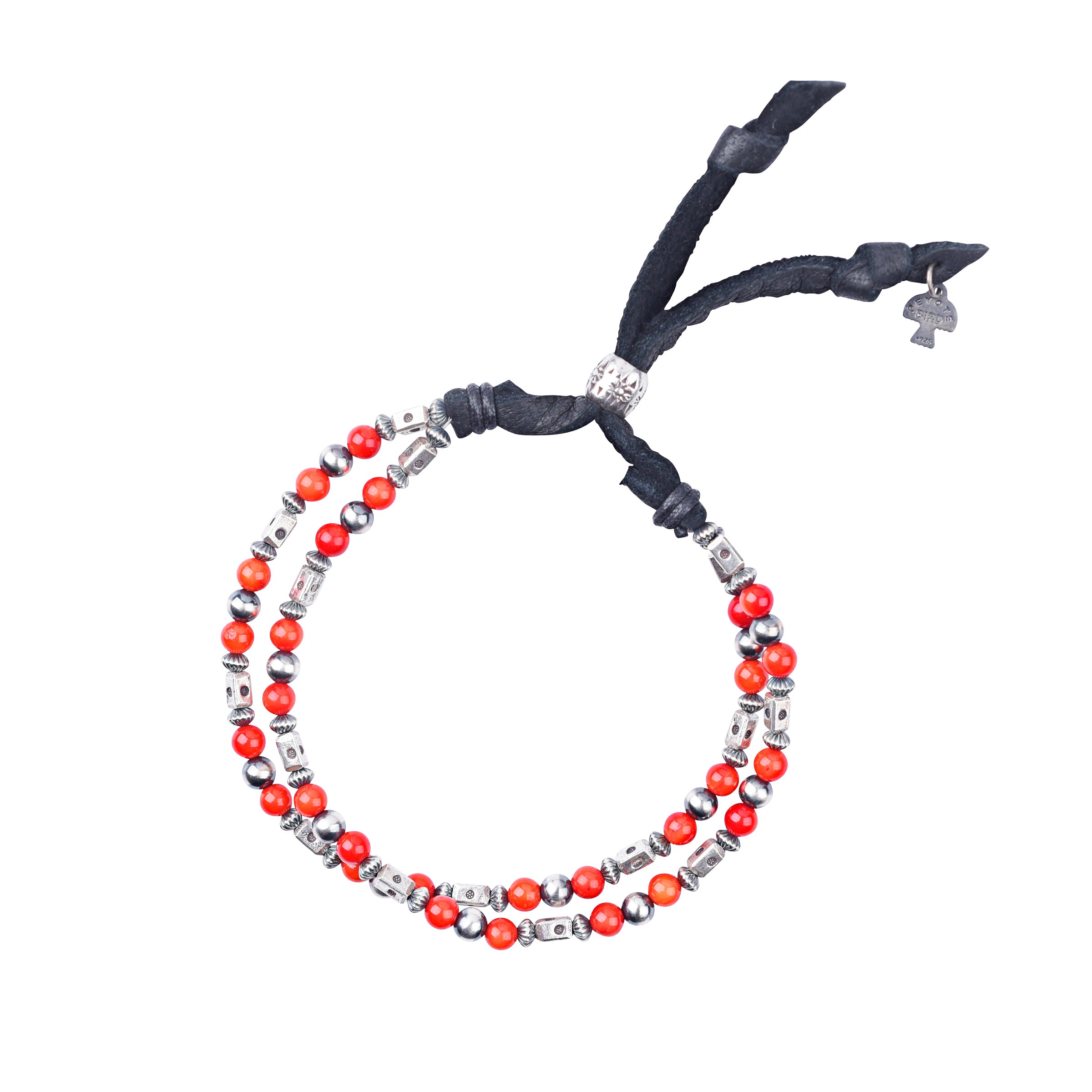 An adjustable bracelet featuring deerskin leather, desert pearls, sterling silver accents and beading, topped off with coral