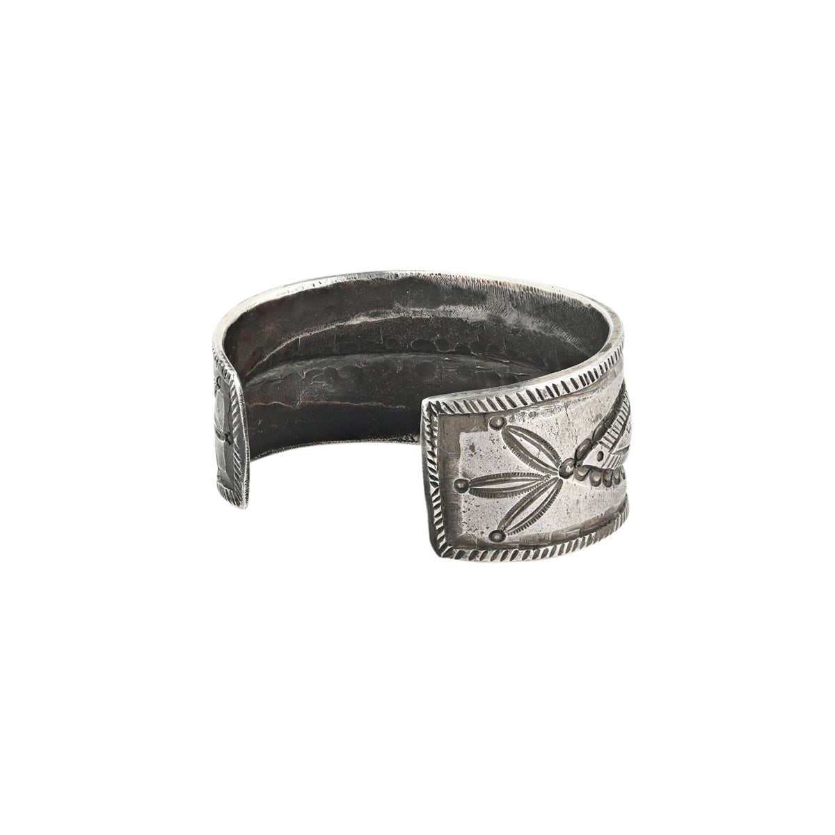 A men's cuff by Jock Favour handcrafted from ingot coin silver and stamped with Southwestern motifs