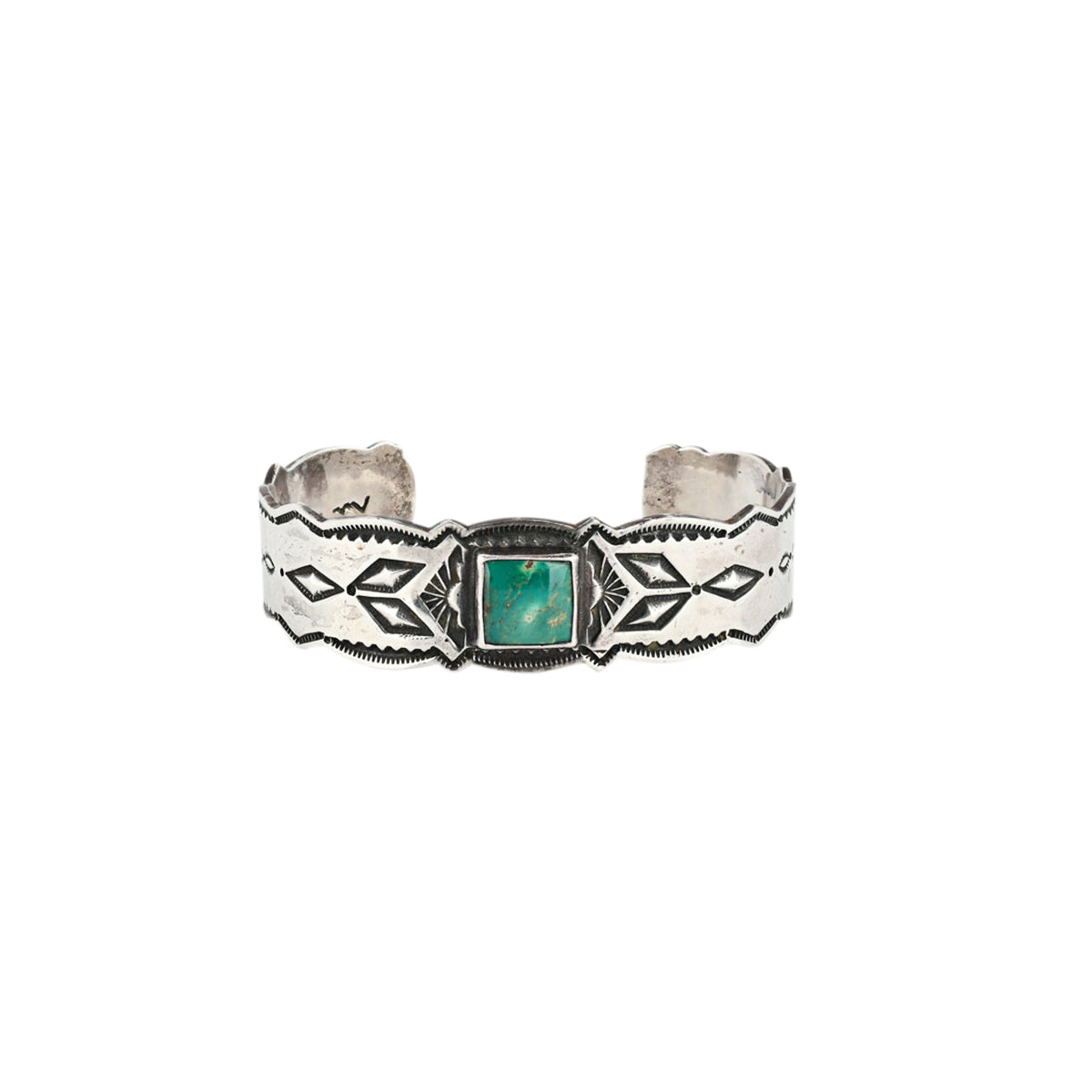 A cuff bracelet featuring a geometric pattern and a green turquoise stone at the center