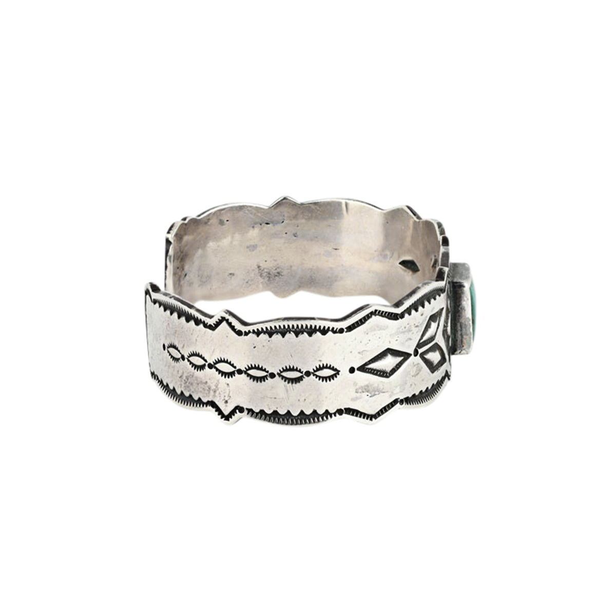 A cuff bracelet featuring a geometric pattern and a green turquoise stone at the center