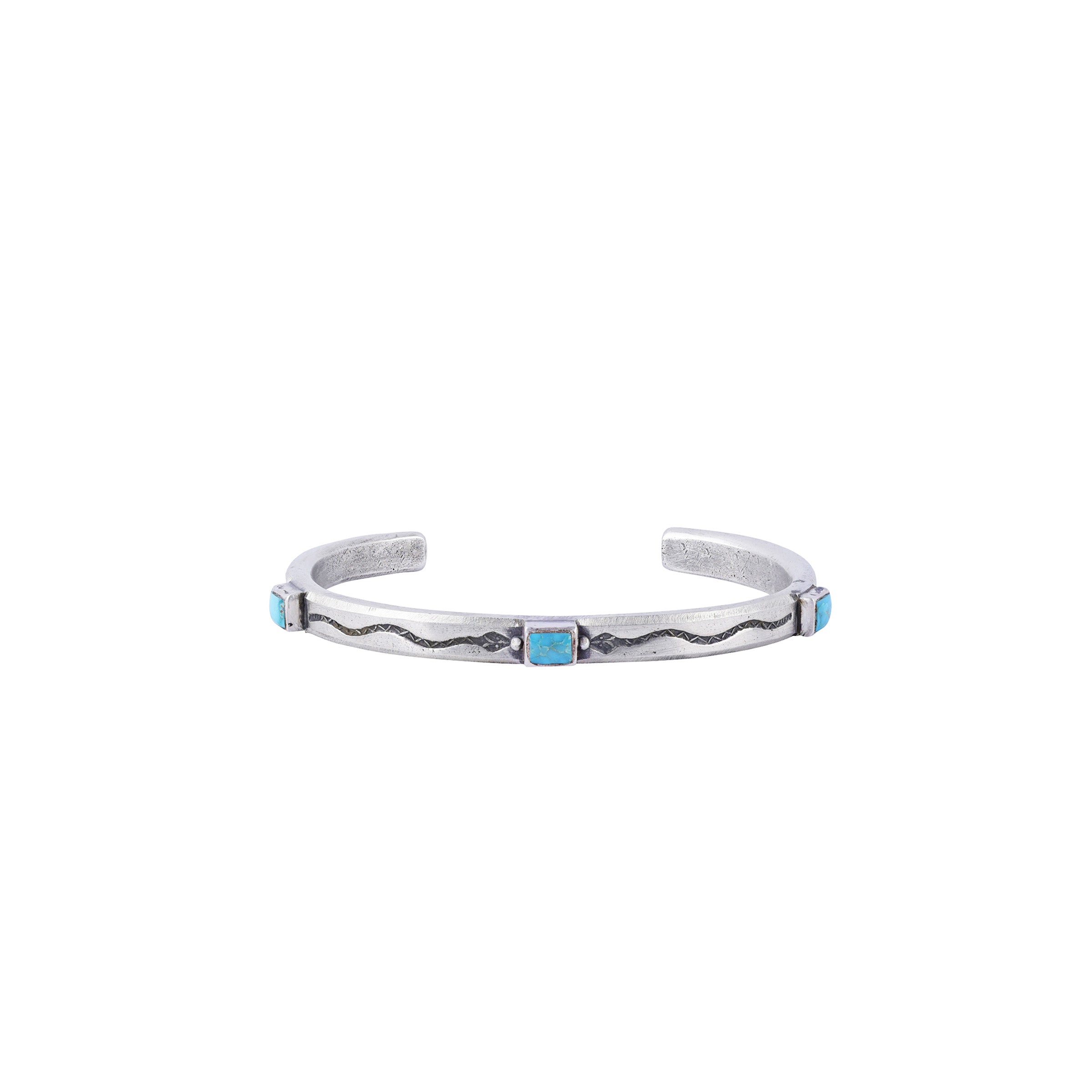 A handmade cuff made with Ingot Coin Silver and Blue Turquoise with stamped snakes