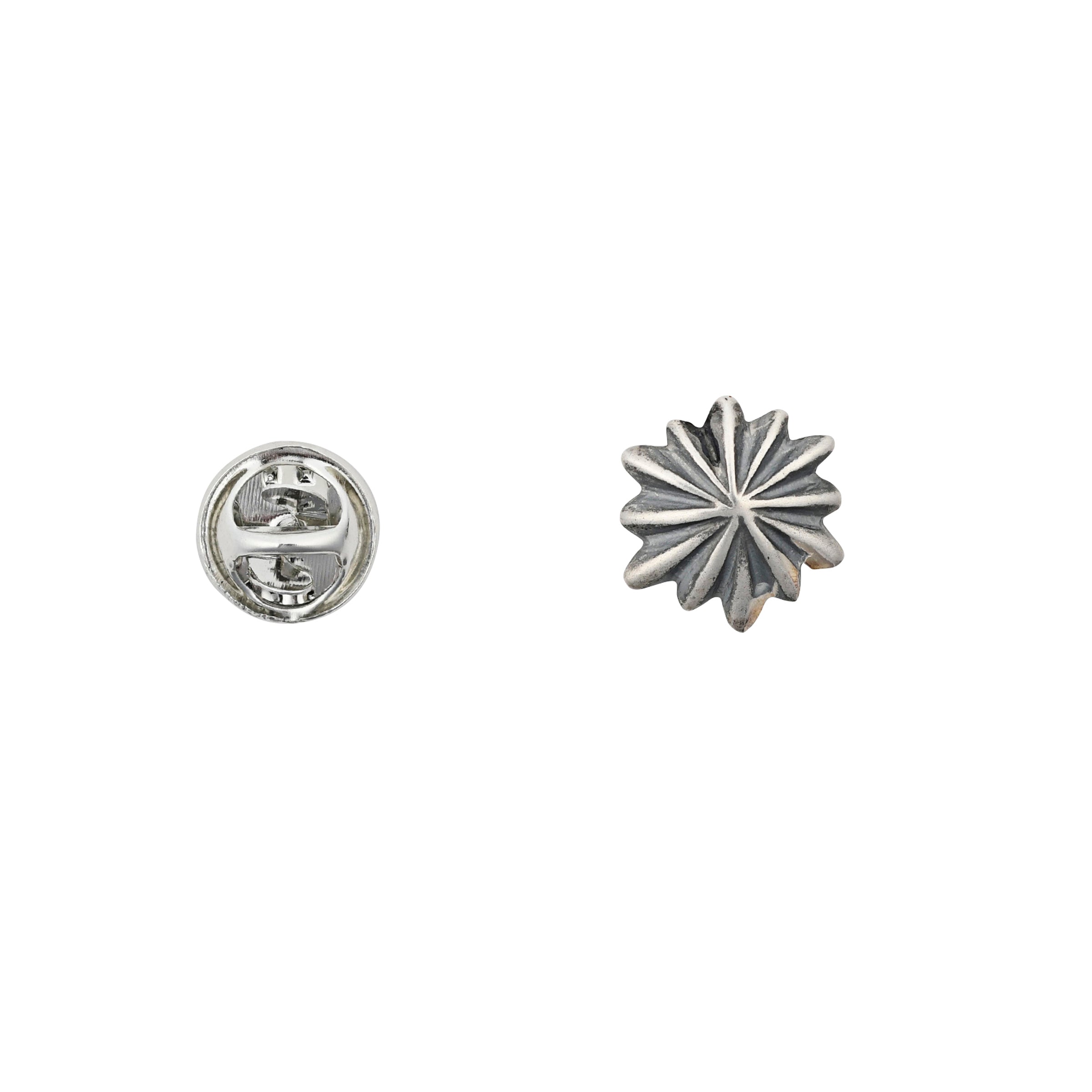silver circular star shaped pin with textured and oxidized detail next to pin back.