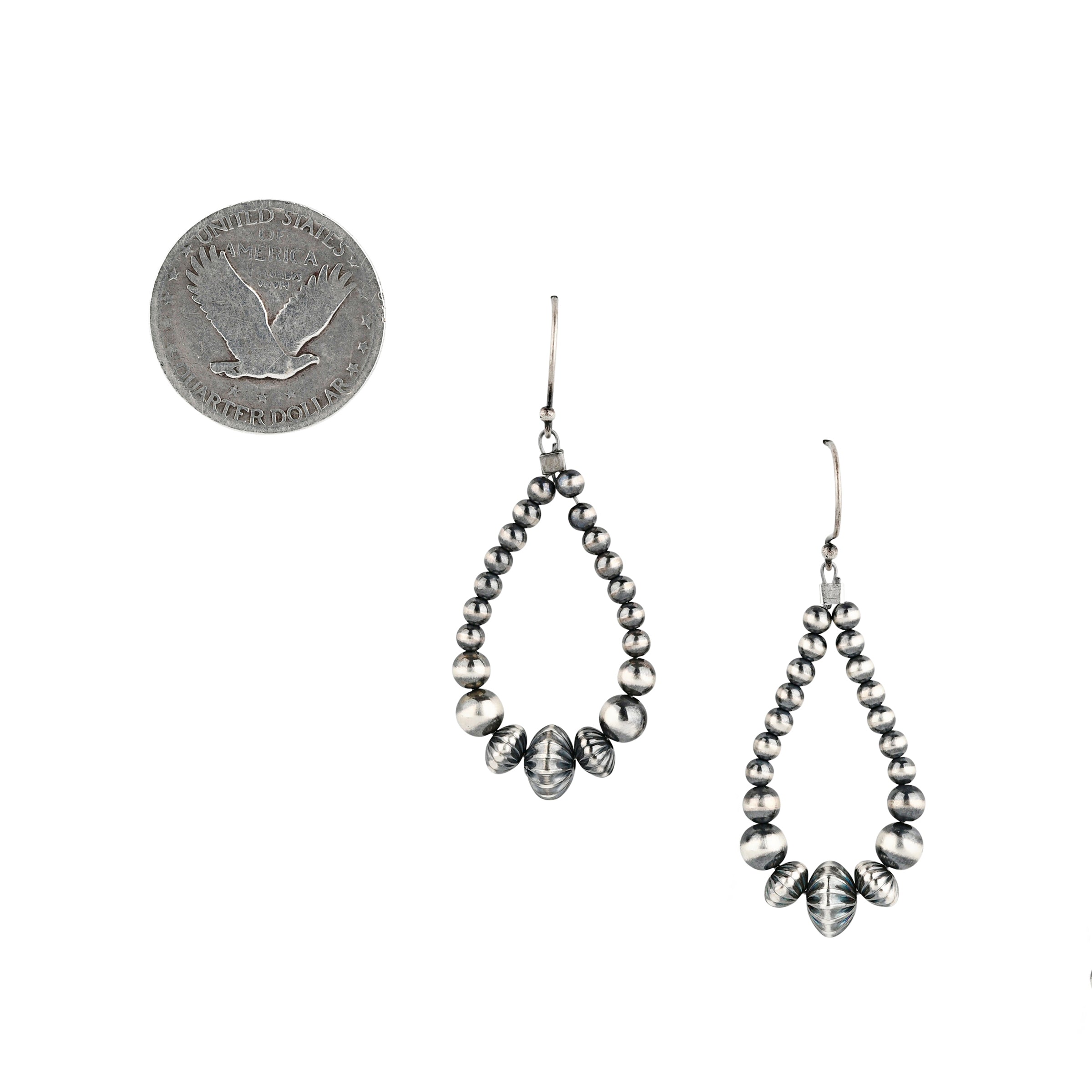 Hand strung assorted desert pearl hoop earrings next to coin for scale