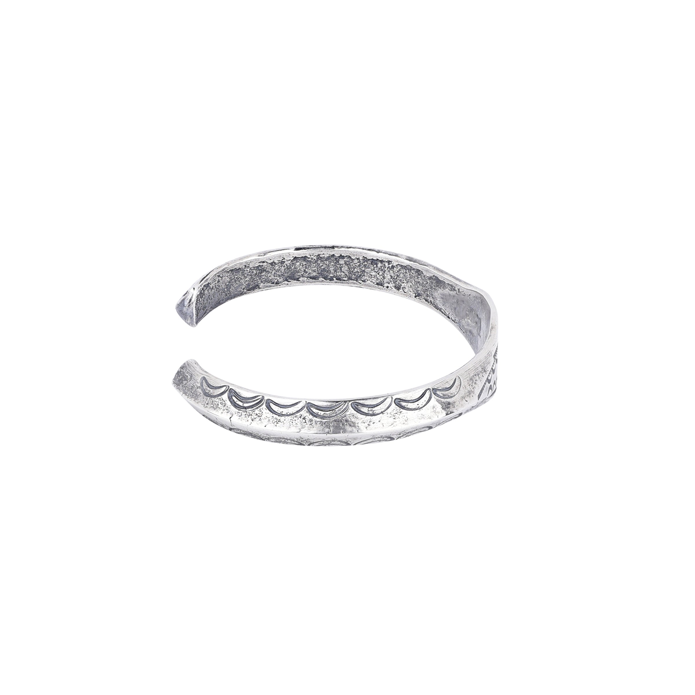 A silver cuff bracelet with intricate stamped patterns, 5 inches in length with a 1/4 inch width.