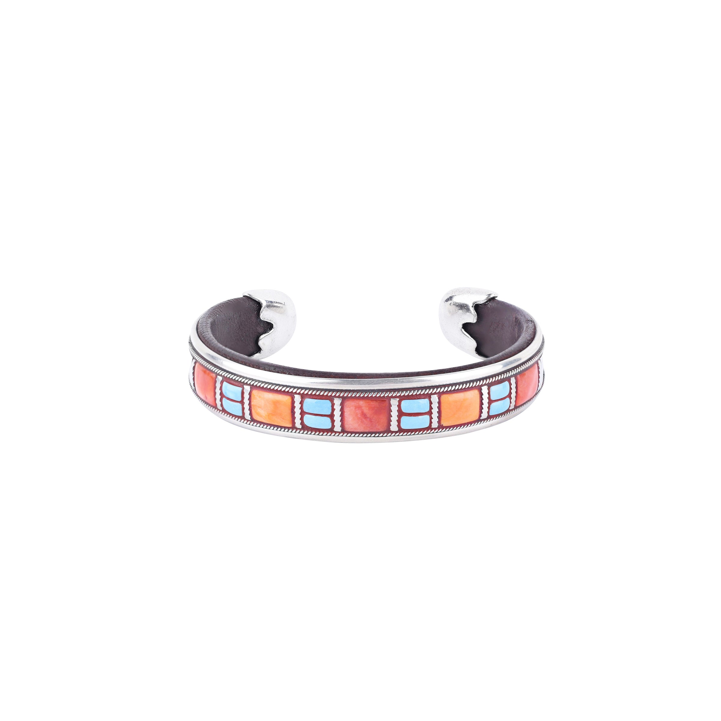 Comfortable brown leather and sterling silver cuff from artisan Ramona Heise. Featuring blue turquoise, orange spiny oyster shell, and red spiny oyster shell inlay. Adjustable and made in USA.