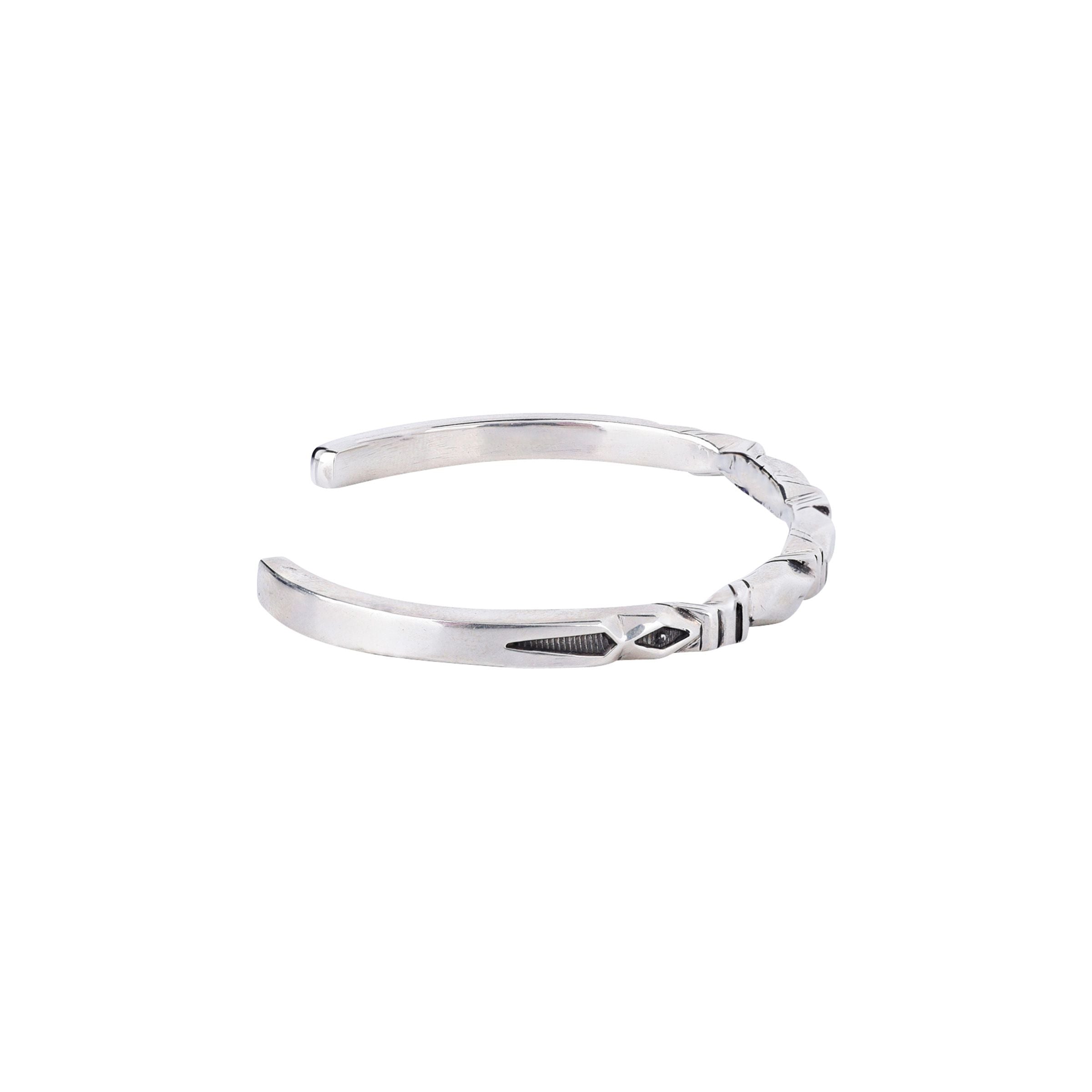 A sterling silver cuff bracelet with a geometric pattern.