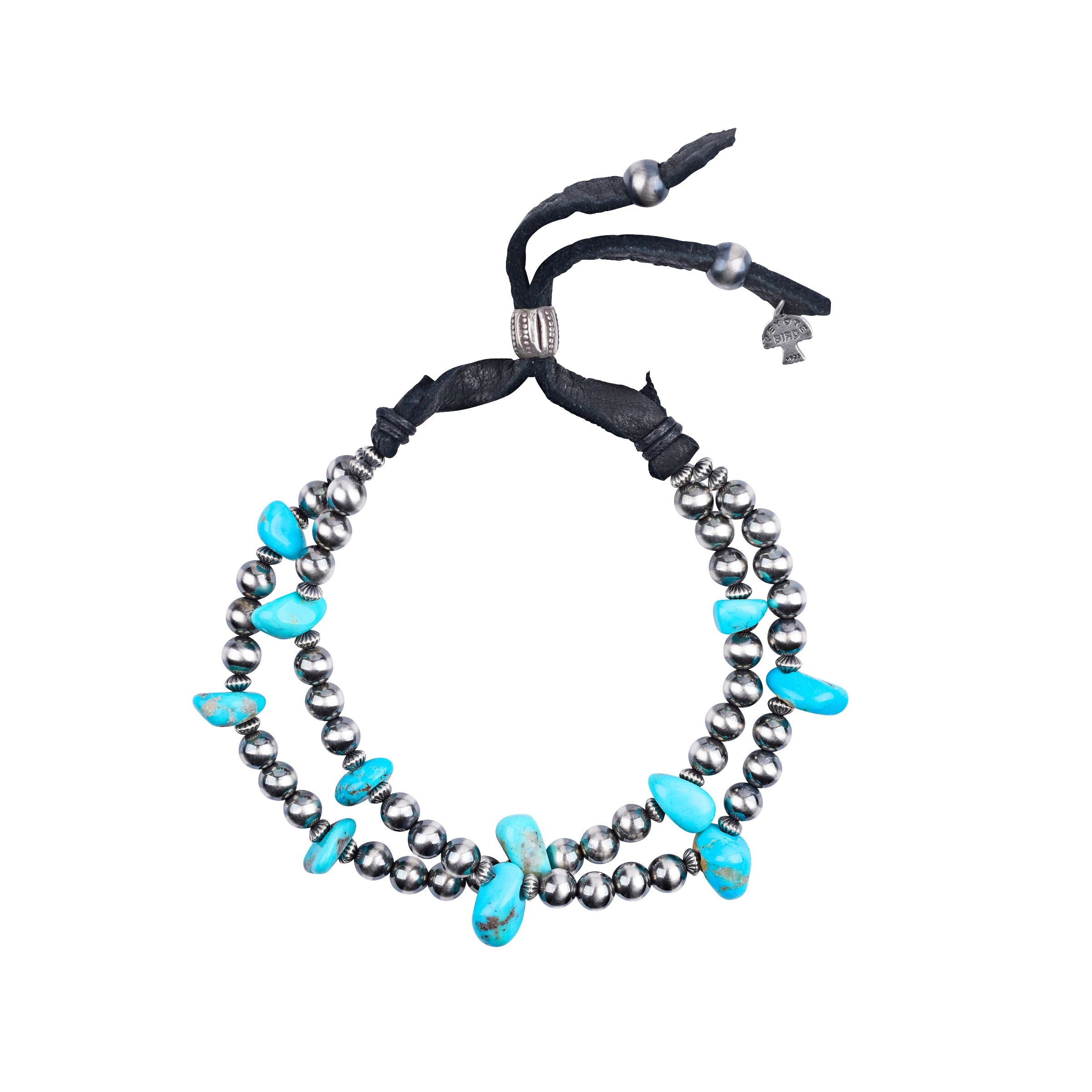An adjustable bracelet with turquoise nuggets and sterling silver desert pearls, featuring deerskin leather.