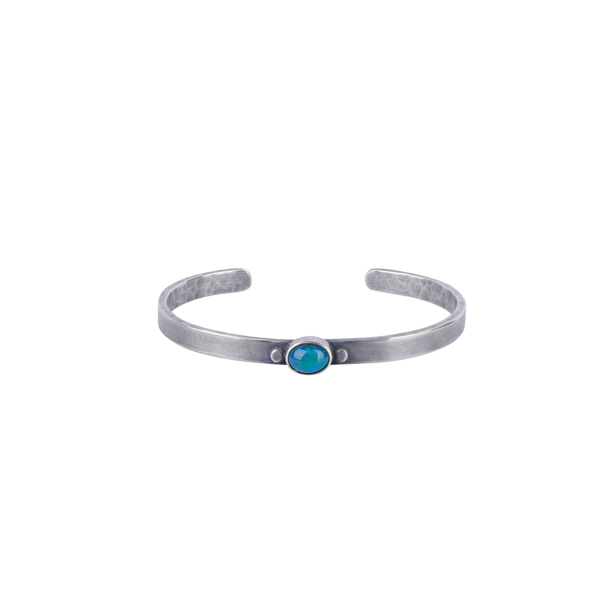 A sterling silver cuff bracelet with a dark blue and green opal stone in the center and a hammered texture.