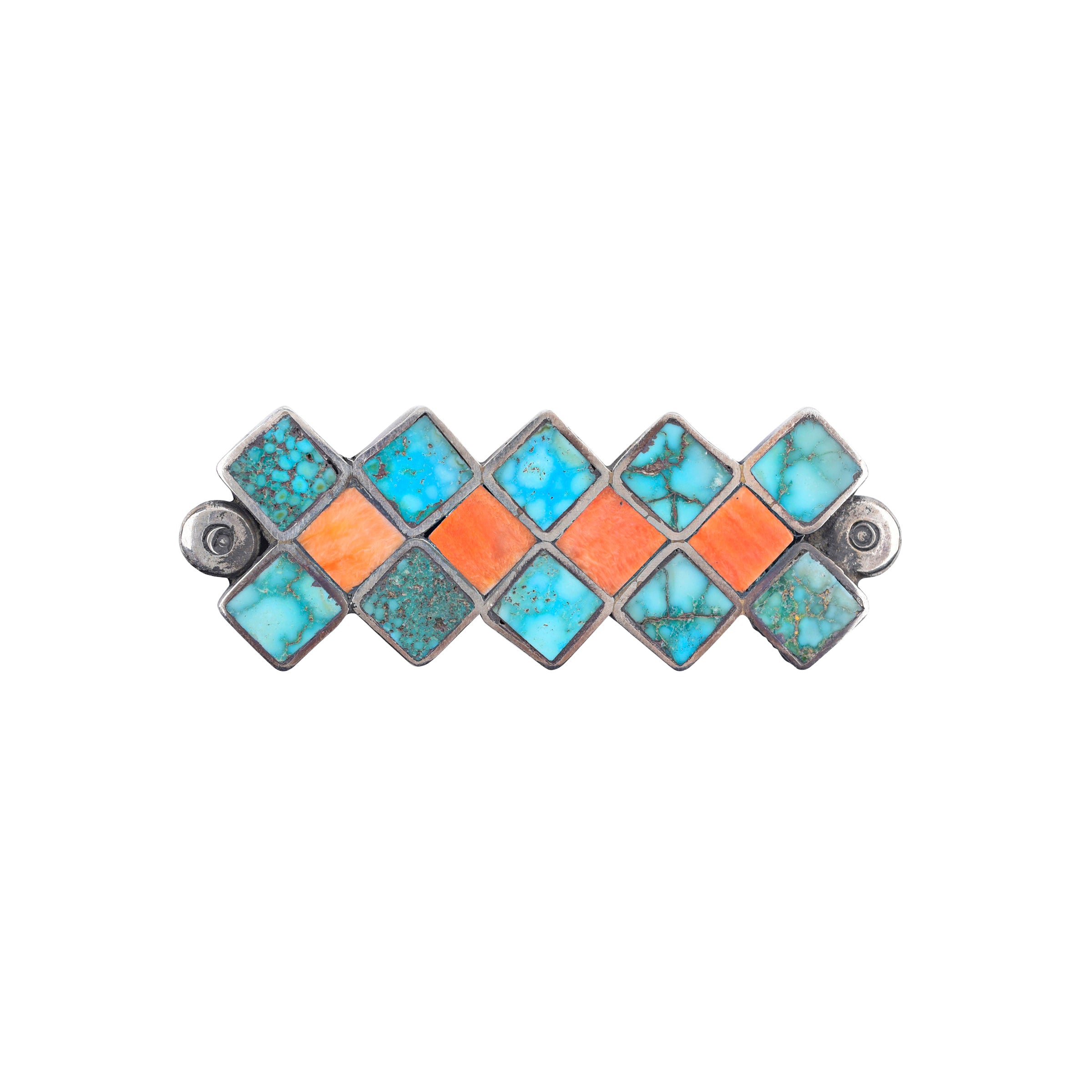 A brooch pin with a geometric pattern, featuring blue turquoise and orange spiny oyster stones set in ingot coin silver.