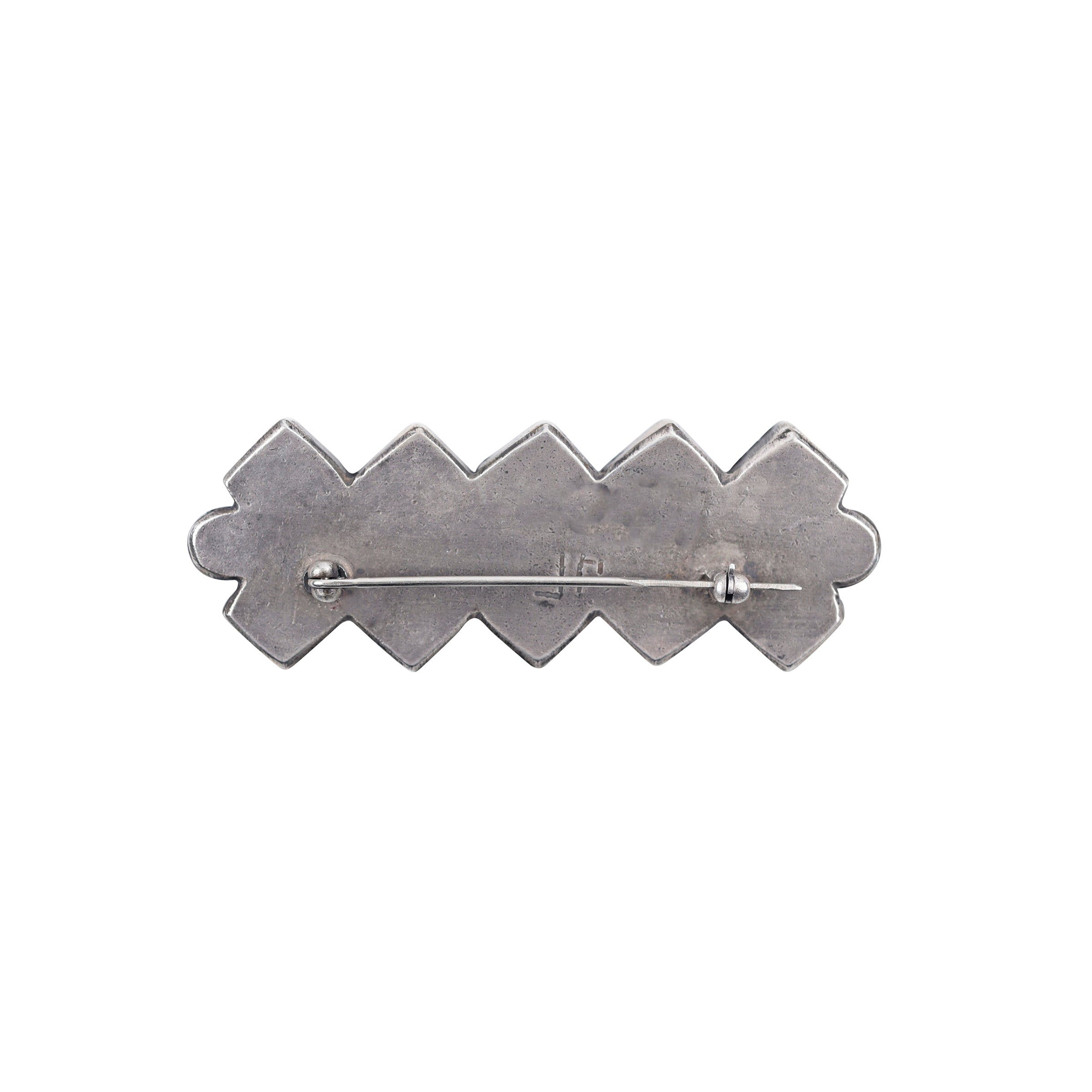 A brooch pin with a geometric pattern, featuring blue turquoise and orange spiny oyster stones set in ingot coin silver.