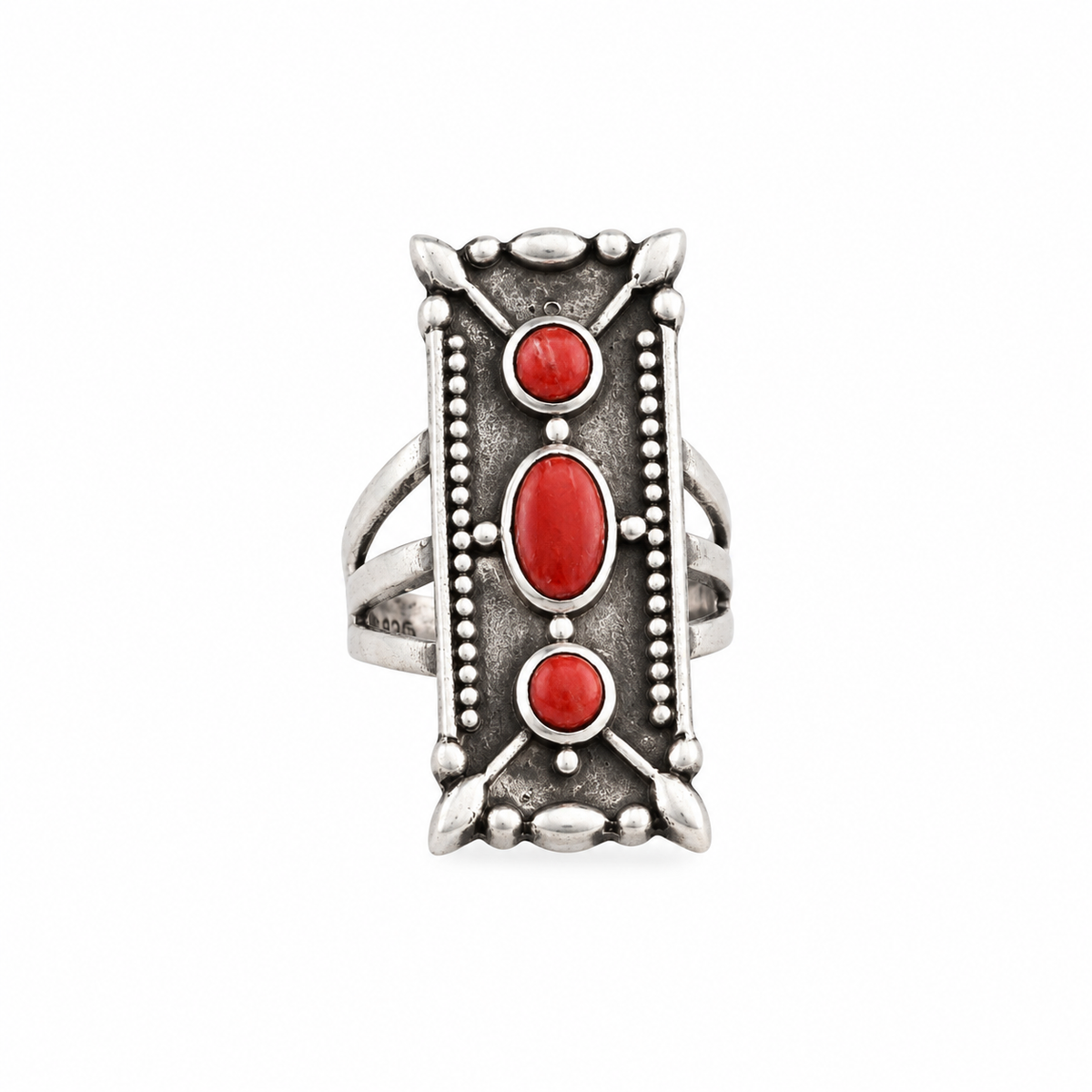 A rectangular sterling silver ring with red coral stones, featuring a textured design around the split shank band.