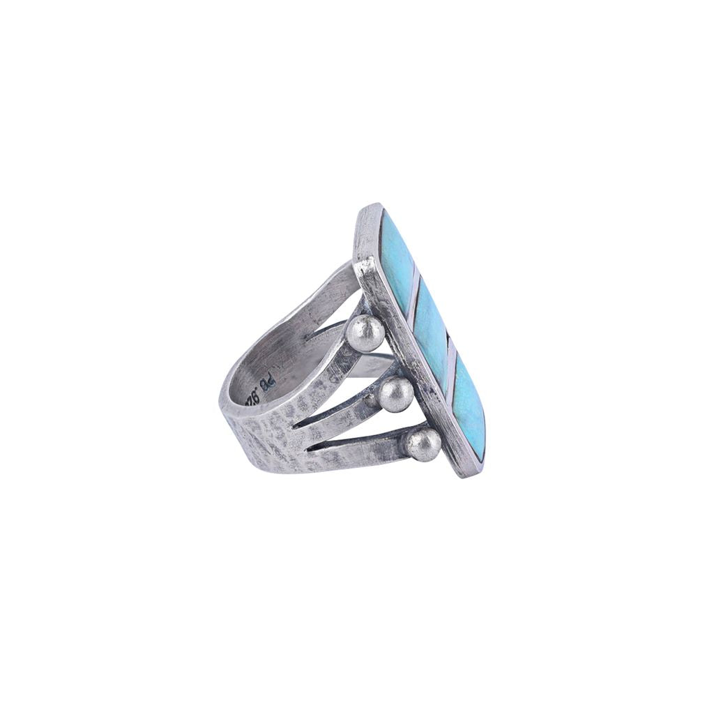 A sterling silver ring featuring three stacked rectangular blue turquoise stones, accented with small silver beads on the sides, with a split shank band.