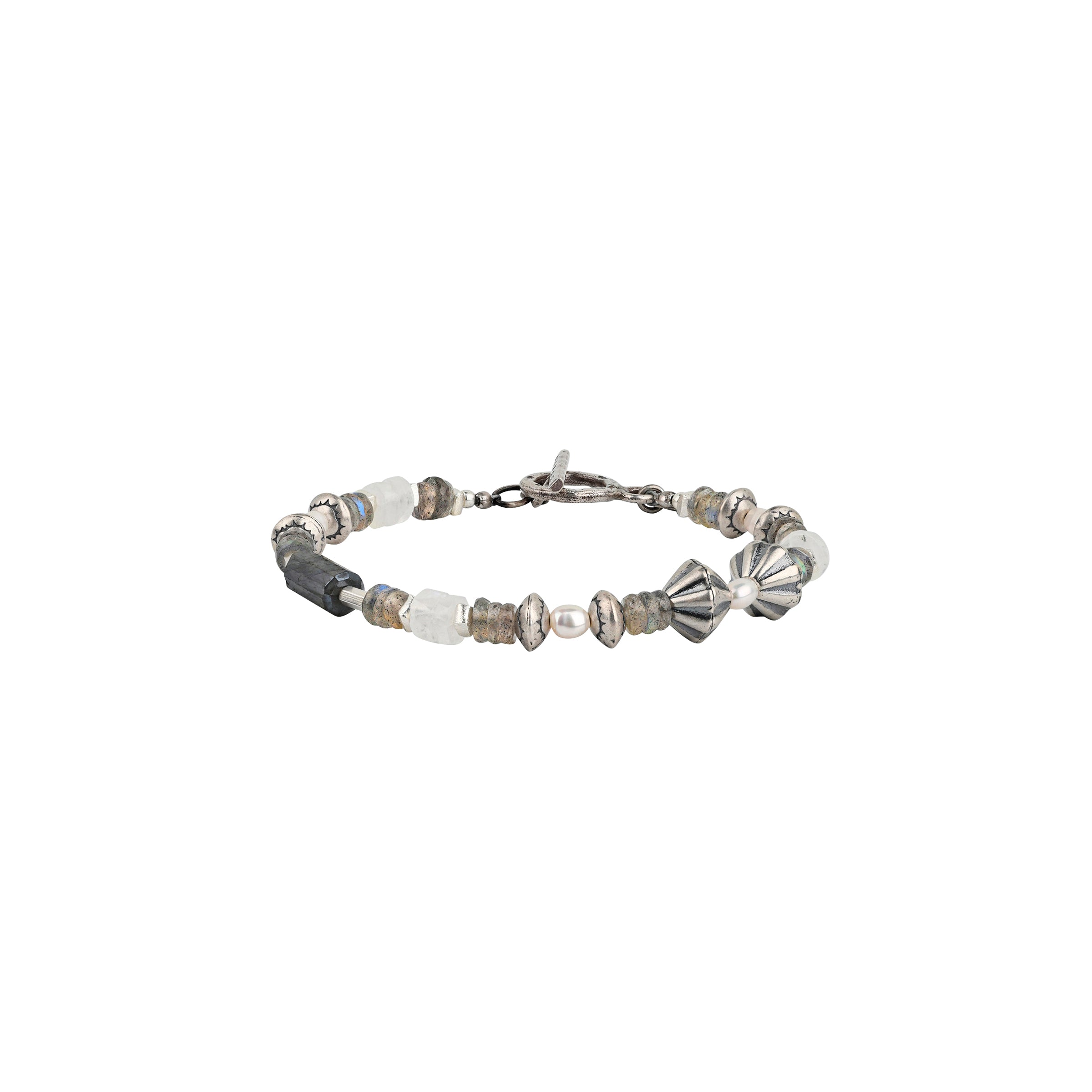 A Peyote Bird Original beaded bracelet strung with Moonstone, Labradorite, Southwestern style sterling silver beading, and stamped sterling silver beads finished with a bar and hoop toggle for a stylish fit