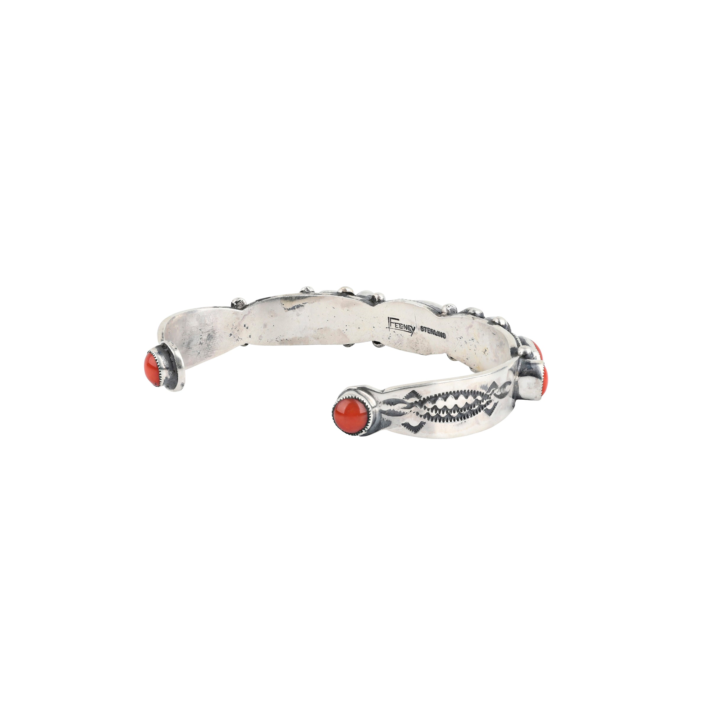 A handmade sterling silver southwestern style cuff inlayed with Red Coral featuring western style stamping