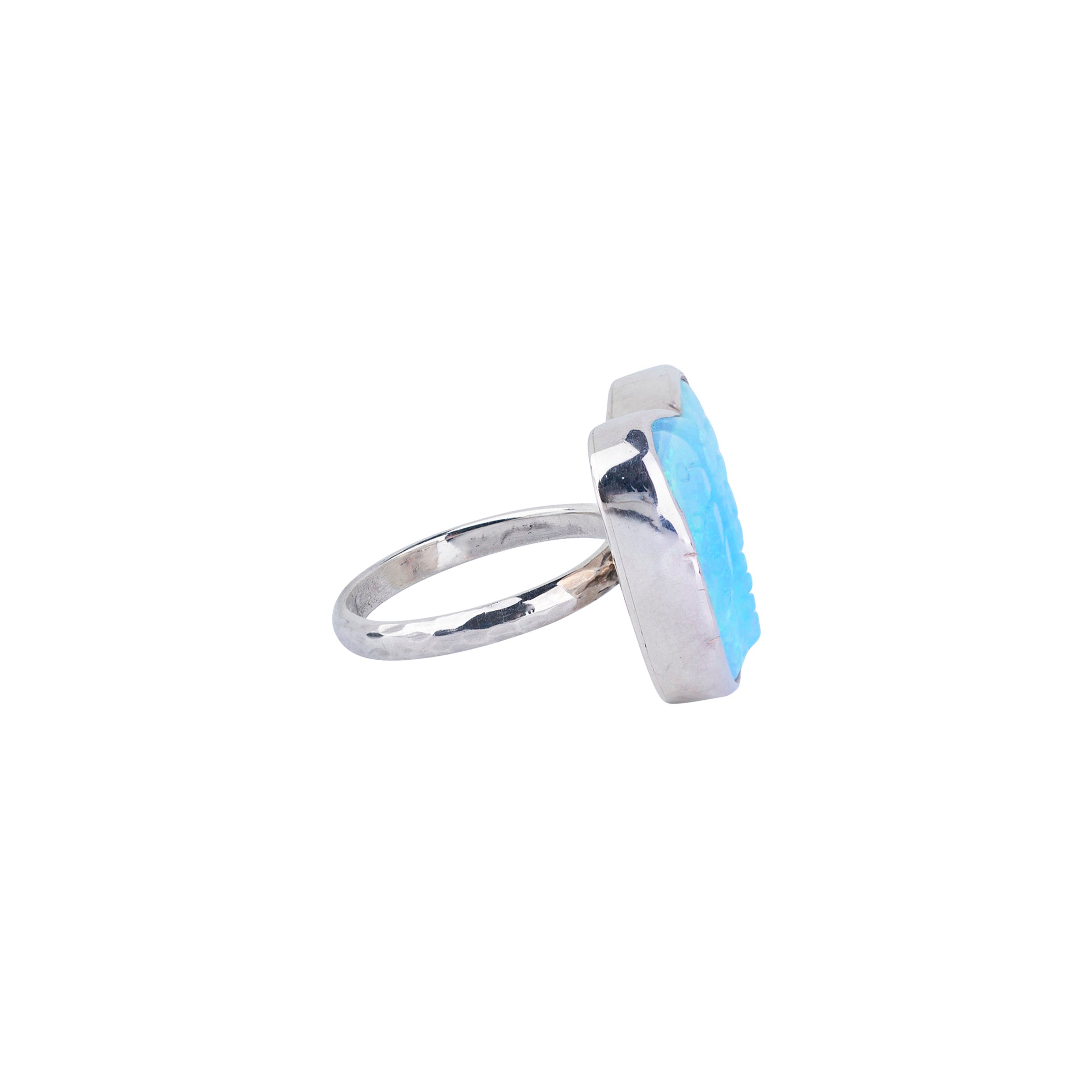 Turquoise carved into butterfly shape and detailing wrapped in sterling silver and single shank ring side view.