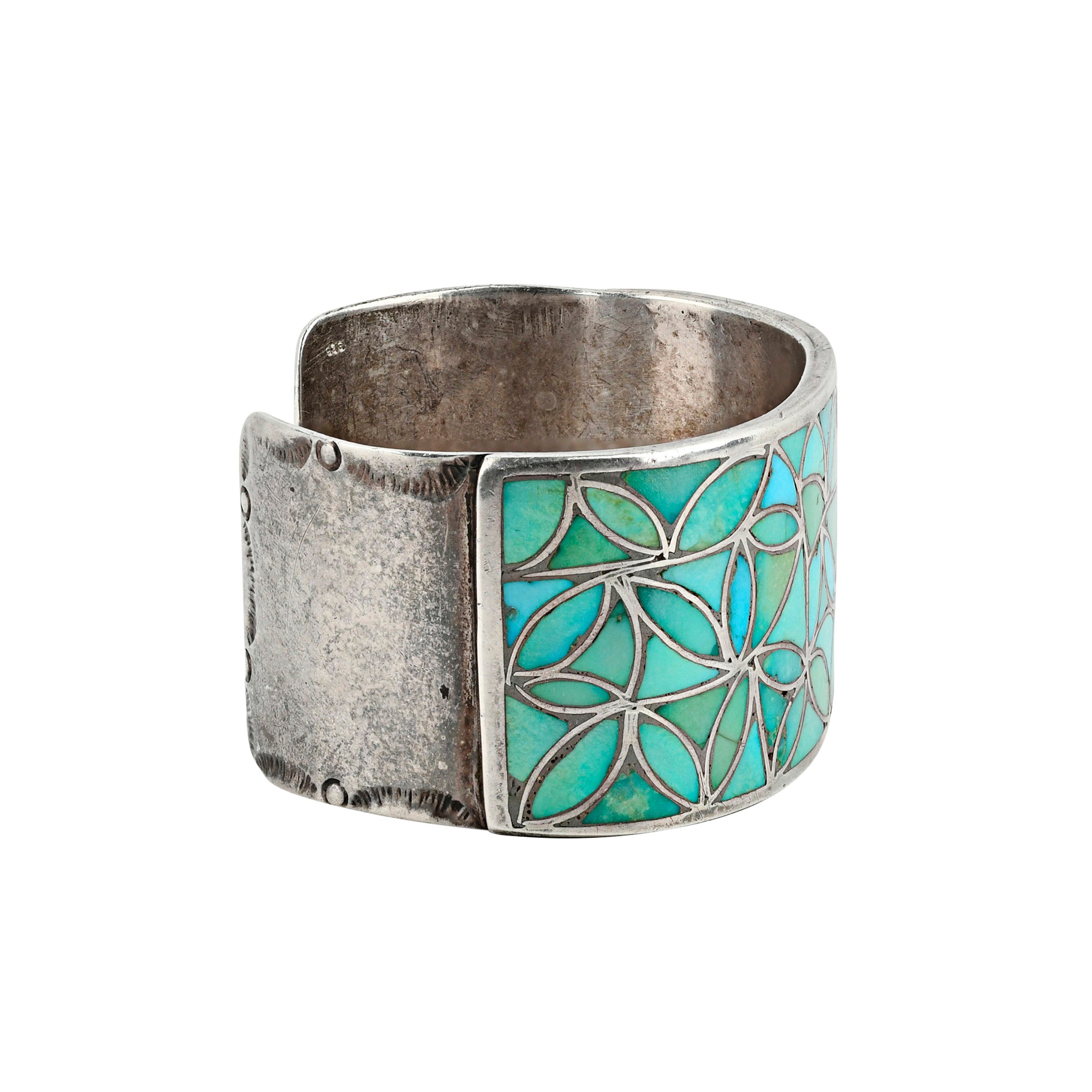 Side view of sterling silver cuff with green and blue turquoise in geometric pattern.