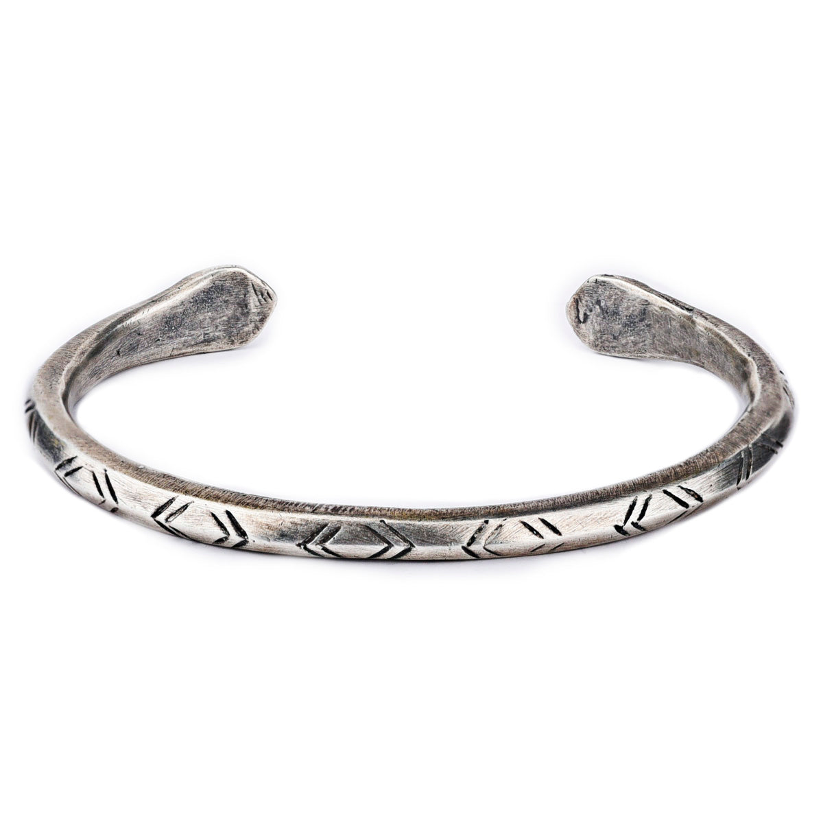 A sterling silver cuff bracelet from artisan Jock Favour featuring a snake motif with opposing snake heads at the ends and intricate stamping resembling snake scales. Made in USA.
