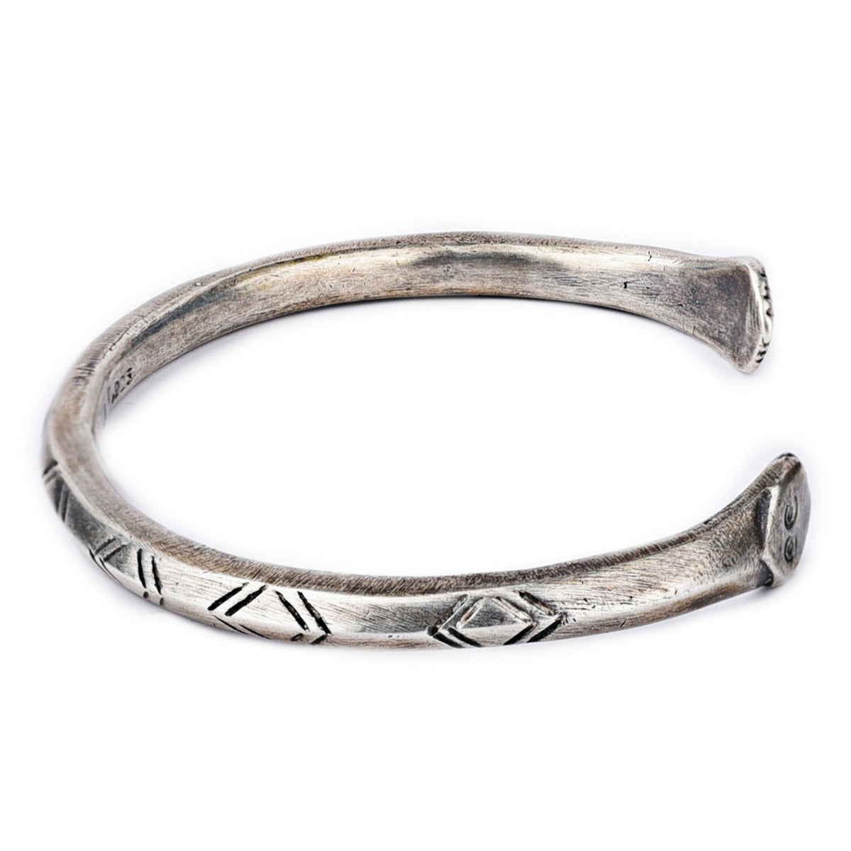 A sterling silver cuff bracelet from artisan Jock Favour featuring a snake motif with opposing snake heads at the ends and intricate stamping resembling snake scales. Made in USA.