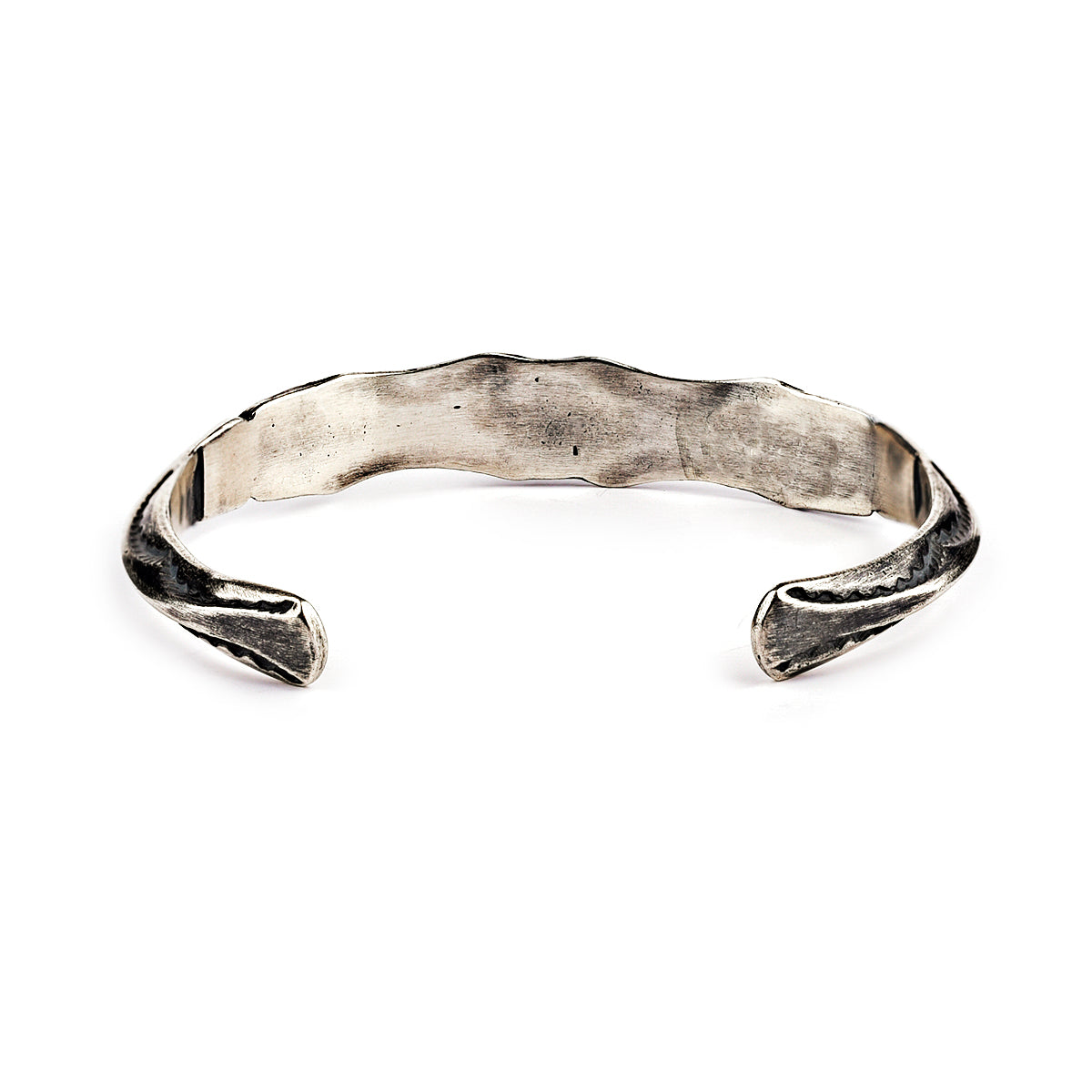 A sterling silver cuff bracelet from artisan Buffalo with intricate stamped geometric patterns and a branded clasp. Made in USA.