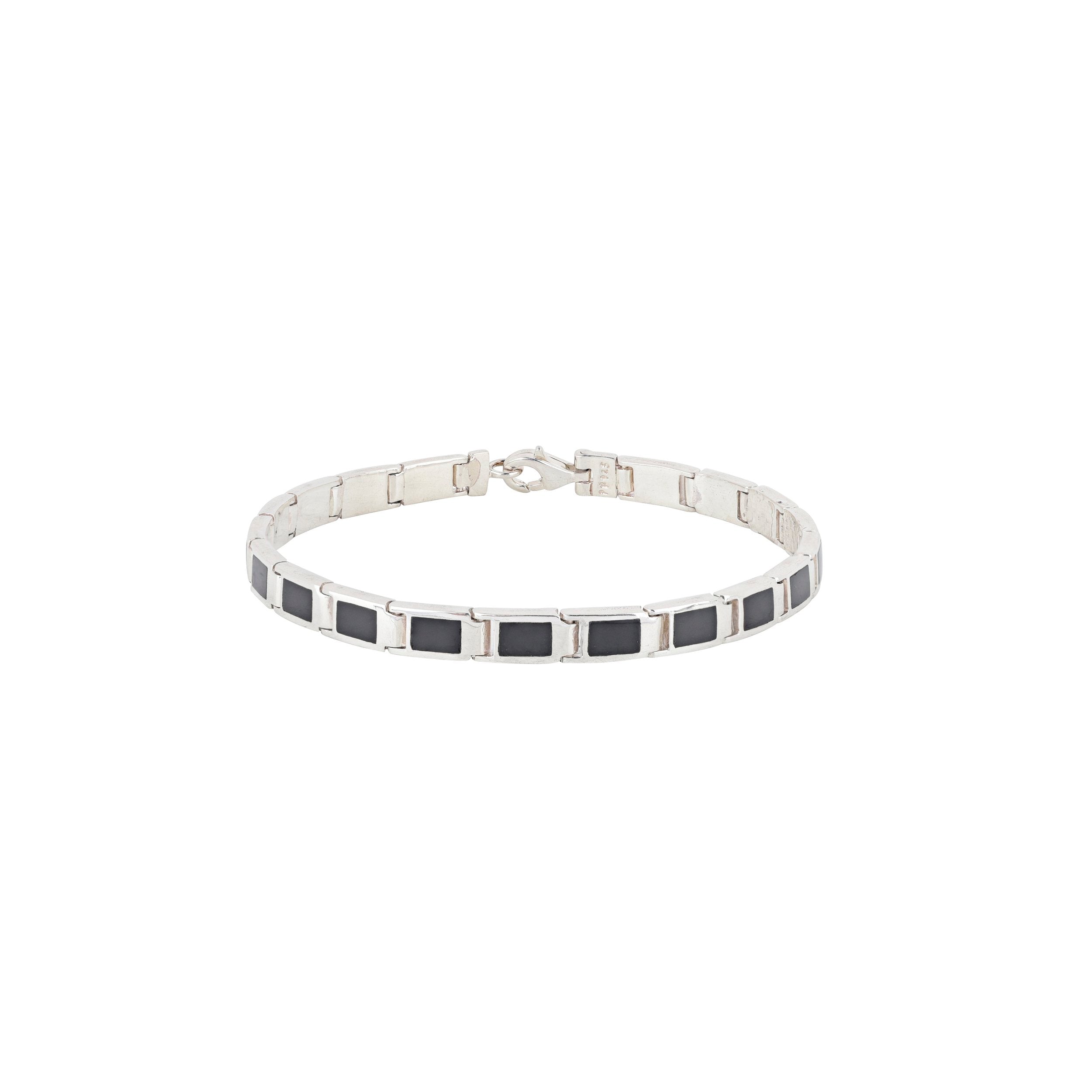 A silver bracelet with black onyx stones, featuring a clasp.