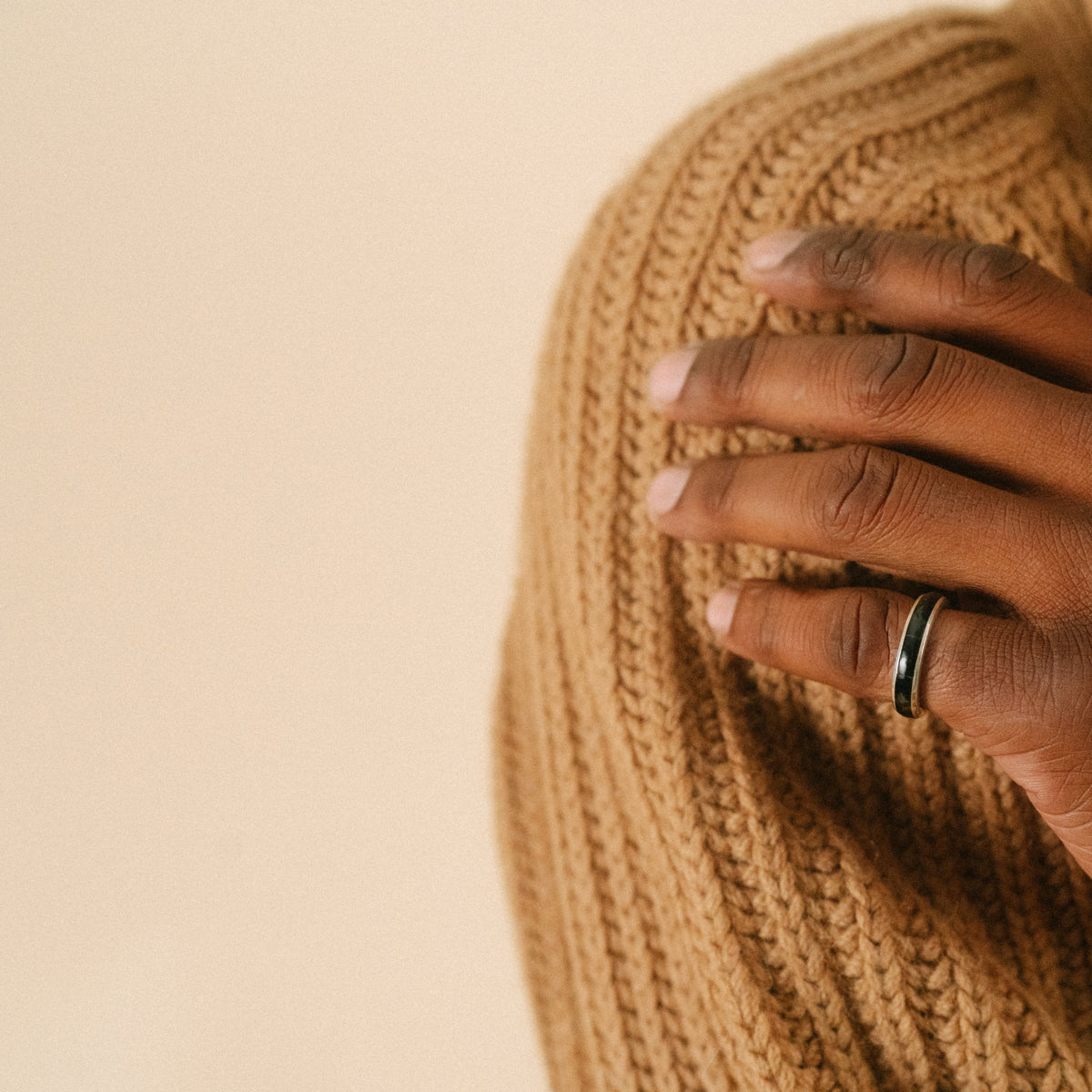 A sterling silver ring with a onyx inlay on a model.