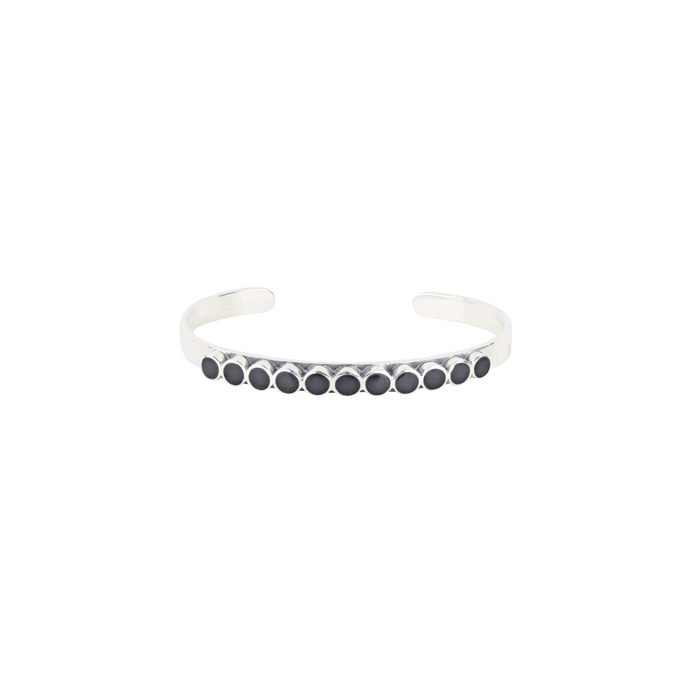 The vintage inspired Mirai cuff from our Bird and Arrow line that features sterling silver with circular onyx stones on top of the band.  