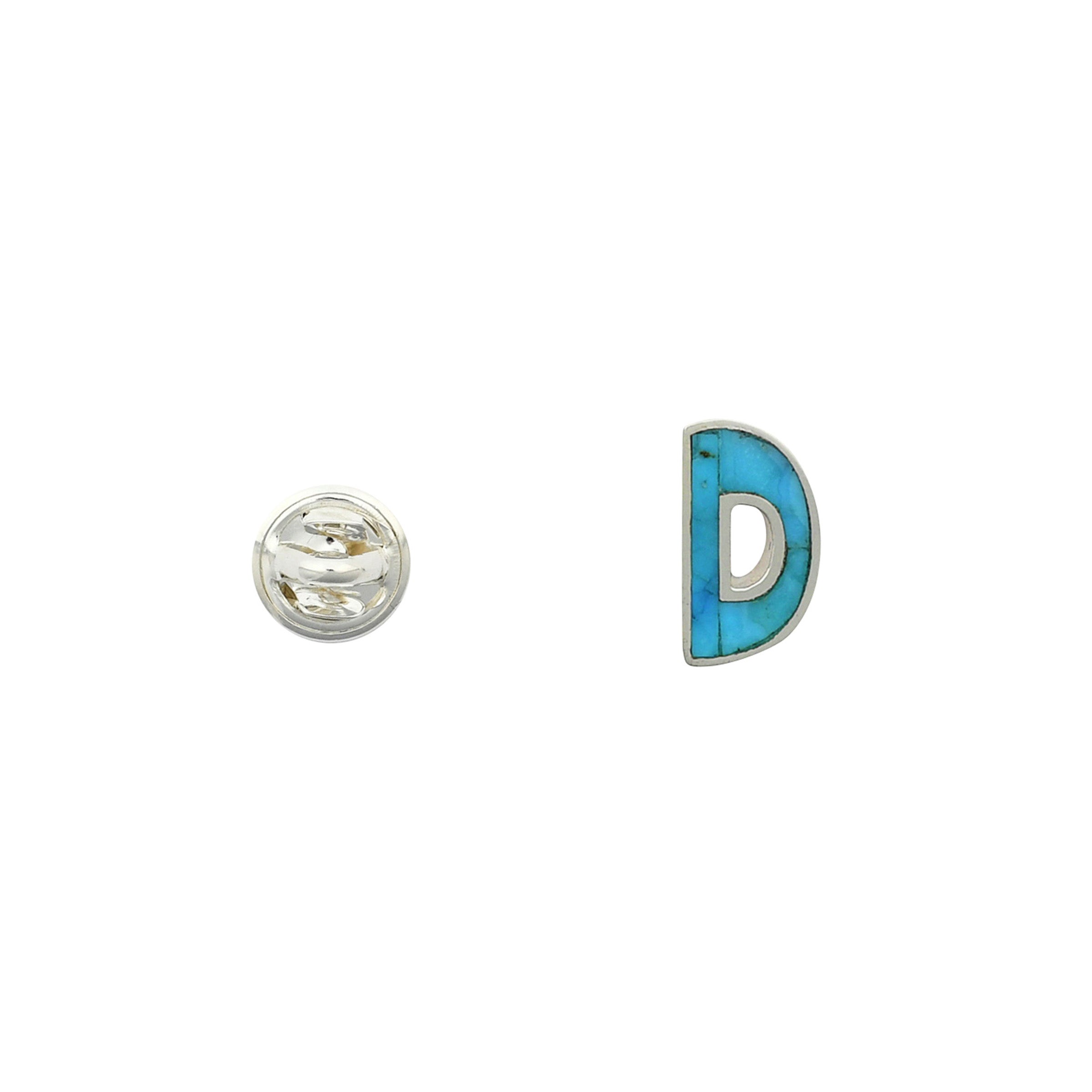 Turquoise letter pin D wrapped in sterling silver next to silver tack back. 