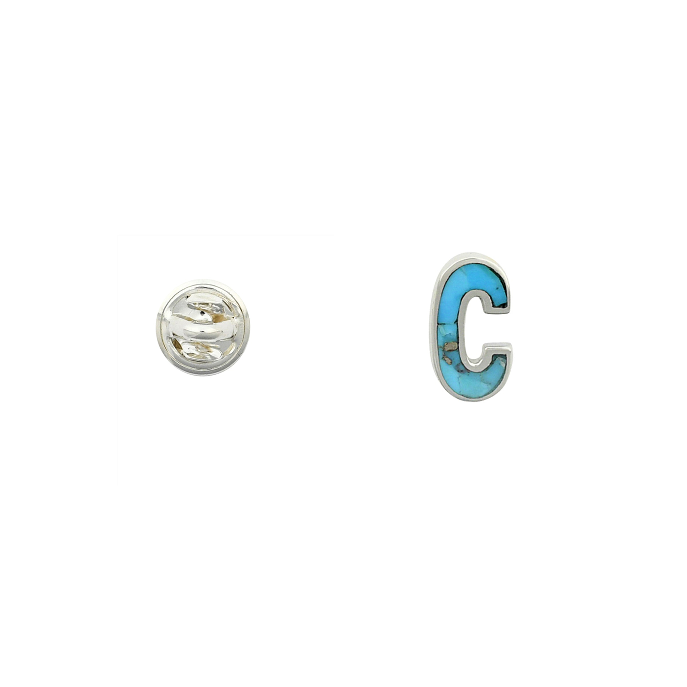 Turquoise letter pin C wrapped in sterling silver next to silver tack back. 