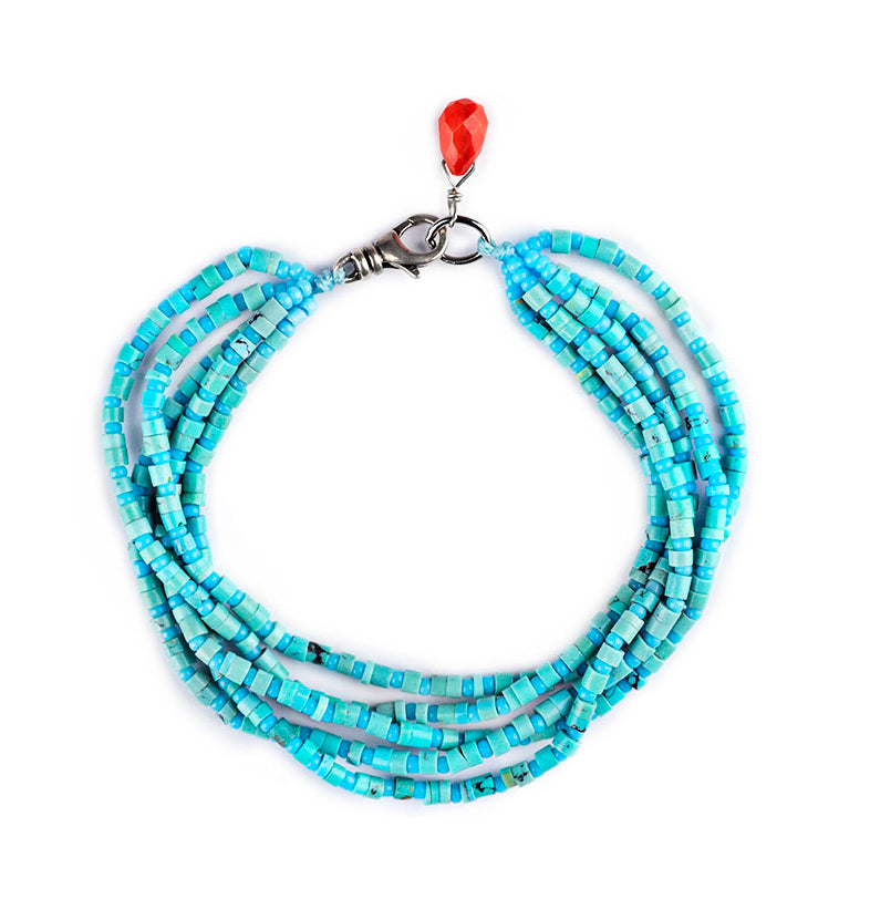 Multi-strand Turquoise bracelet with sterling silver clasp and one coral faceted bead. 