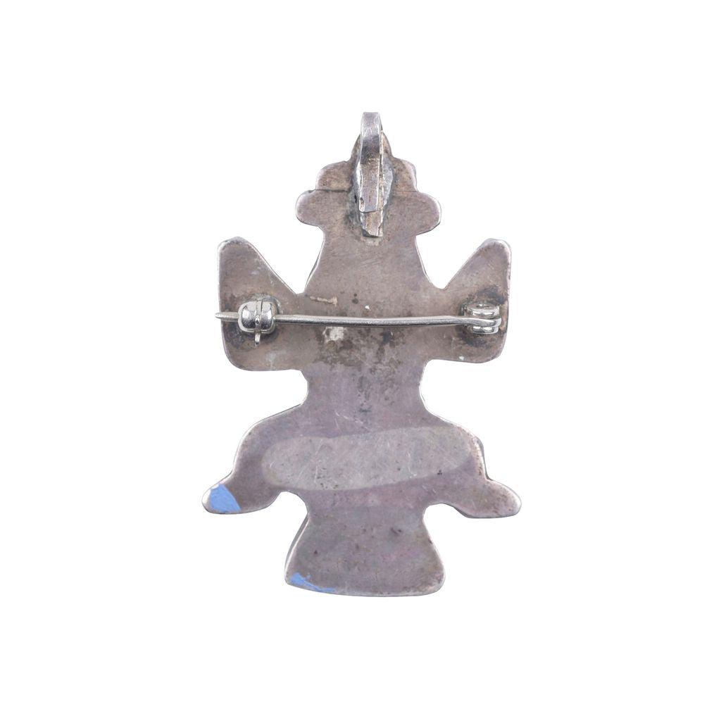 A vintage Zuni mini knifewing pin with geometric patterns and multicolored stones attached to a metal clip.