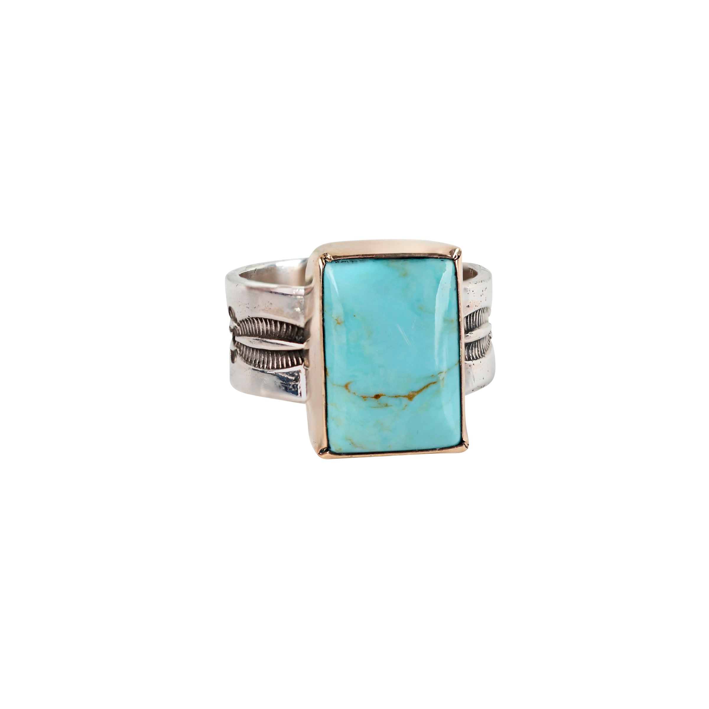 The El Dorado Ring by Peyote Bird Designs is a bold statement ring featuring a rectangular Blue Turquoise as the centerpiece surrounded by 14k Gold Plate on a stamped Sterling Silver band with Santa Fe style motifs.