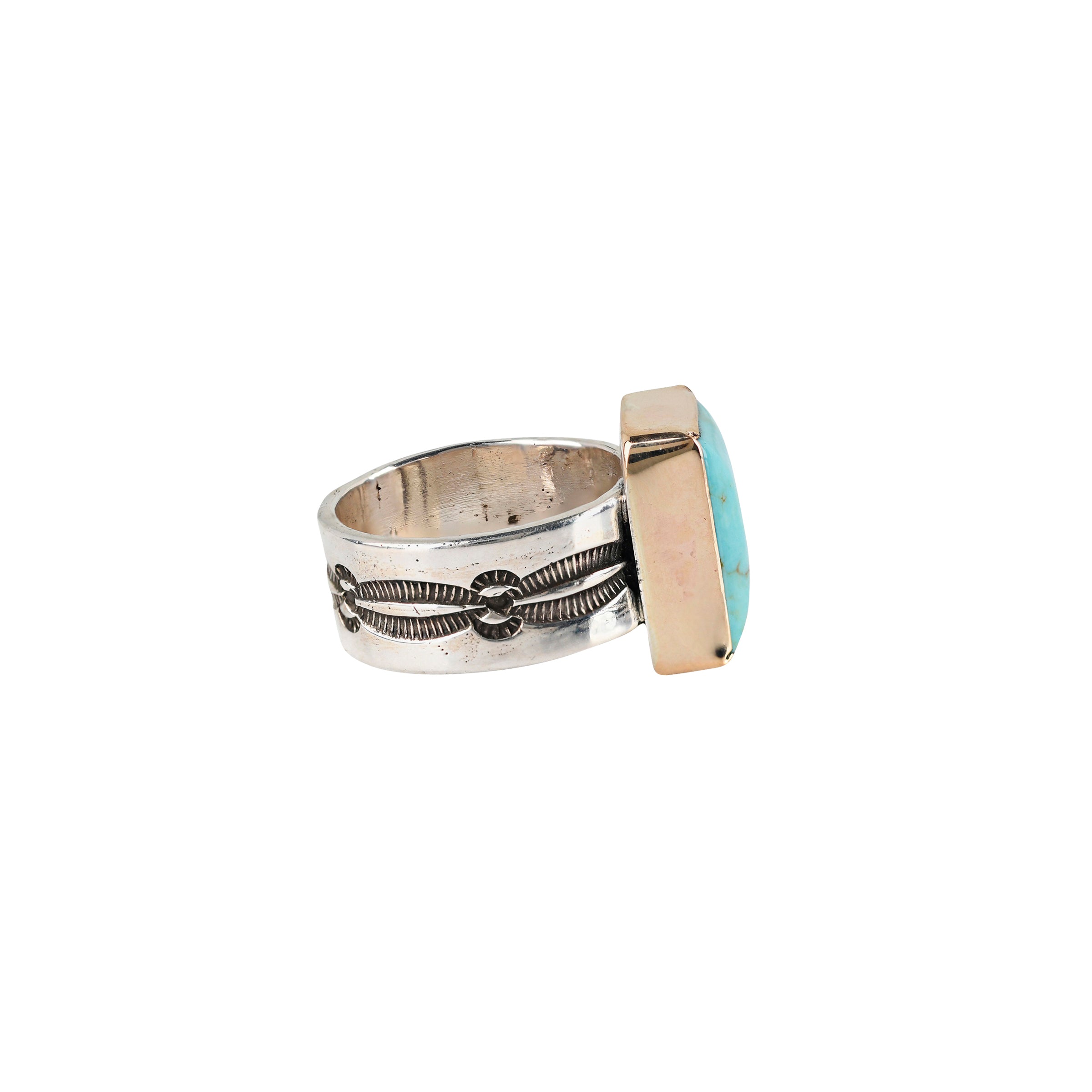 The El Dorado Ring by Peyote Bird Designs is a bold statement ring featuring a rectangular Blue Turquoise as the centerpiece surrounded by 14k Gold Plate on a stamped Sterling Silver band with Santa Fe style motifs.