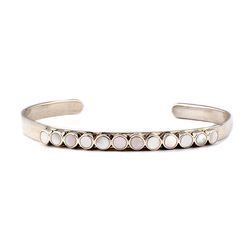 The vintage inspired Mirai cuff from our Bird and Arrow line that features sterling silver with circular white opal stones on top of the band.  
