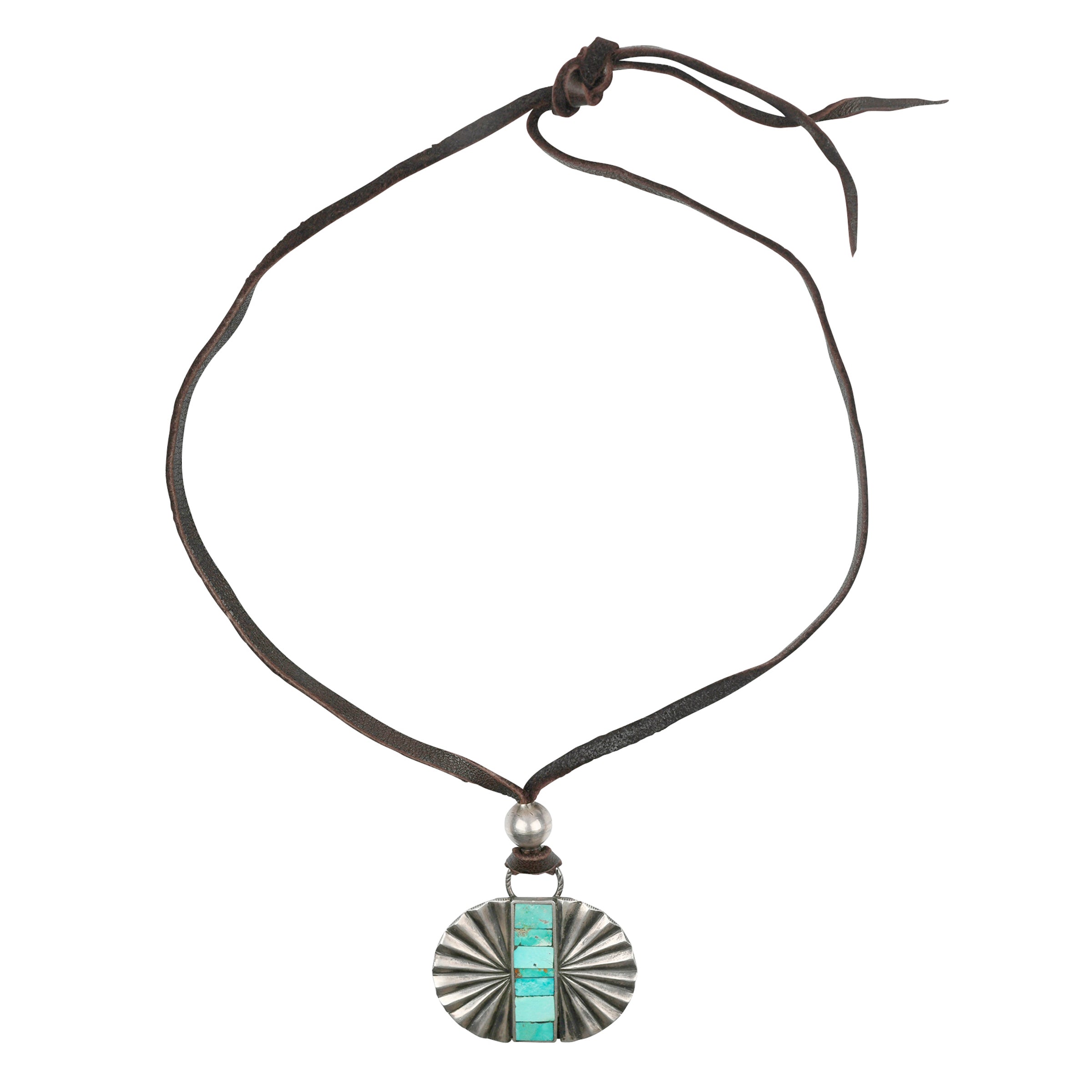 A large pendant necklace of cast Sterling Silver with sunburst patterning featuring a strip of mosaic Turquoise in the middle. Strung on soft deerskin leather. As seen in the Sundance Catalog!