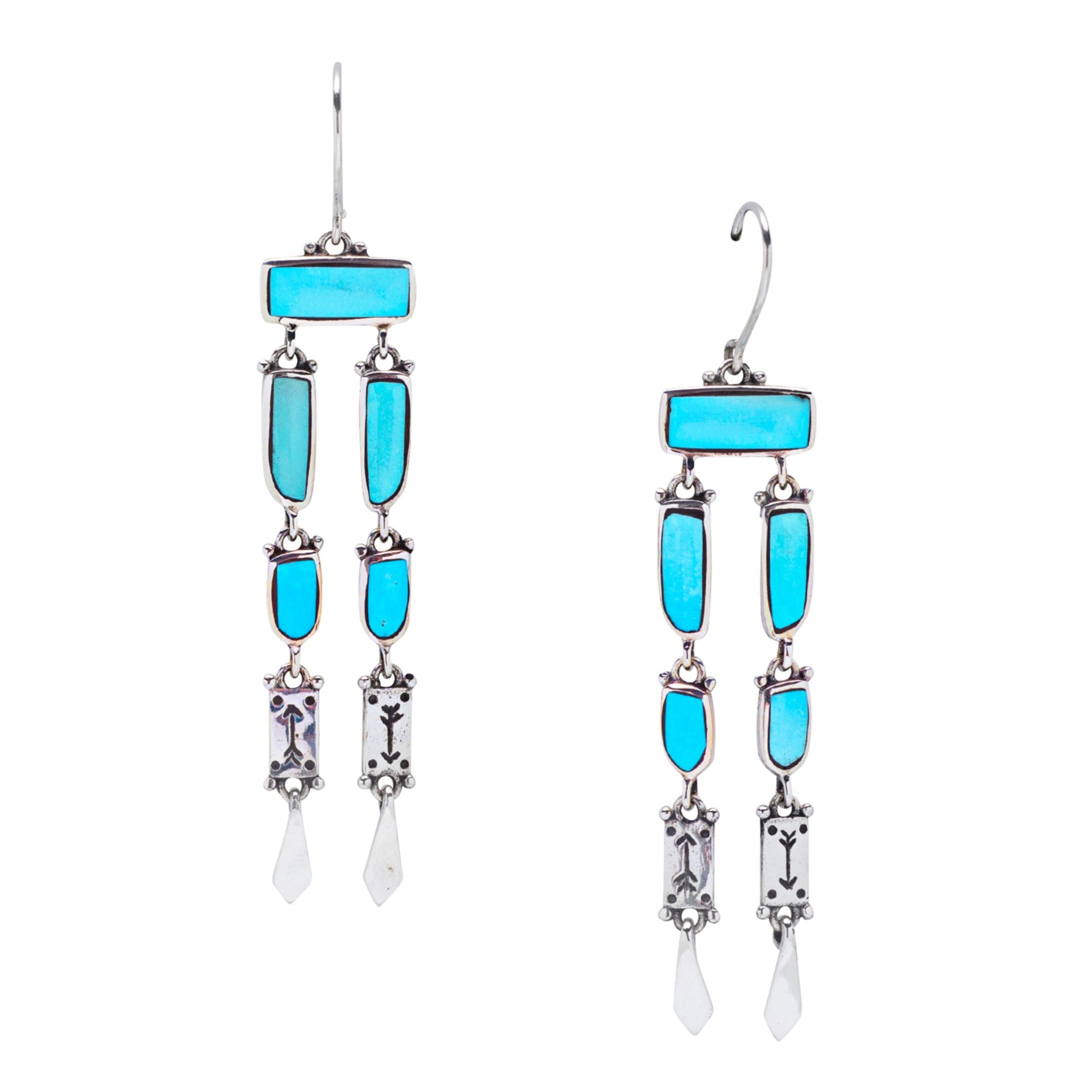 A pair of sterling silver dangle earrings with blue turquoise and stamped arrows in the silver near the bottom of the earrings.