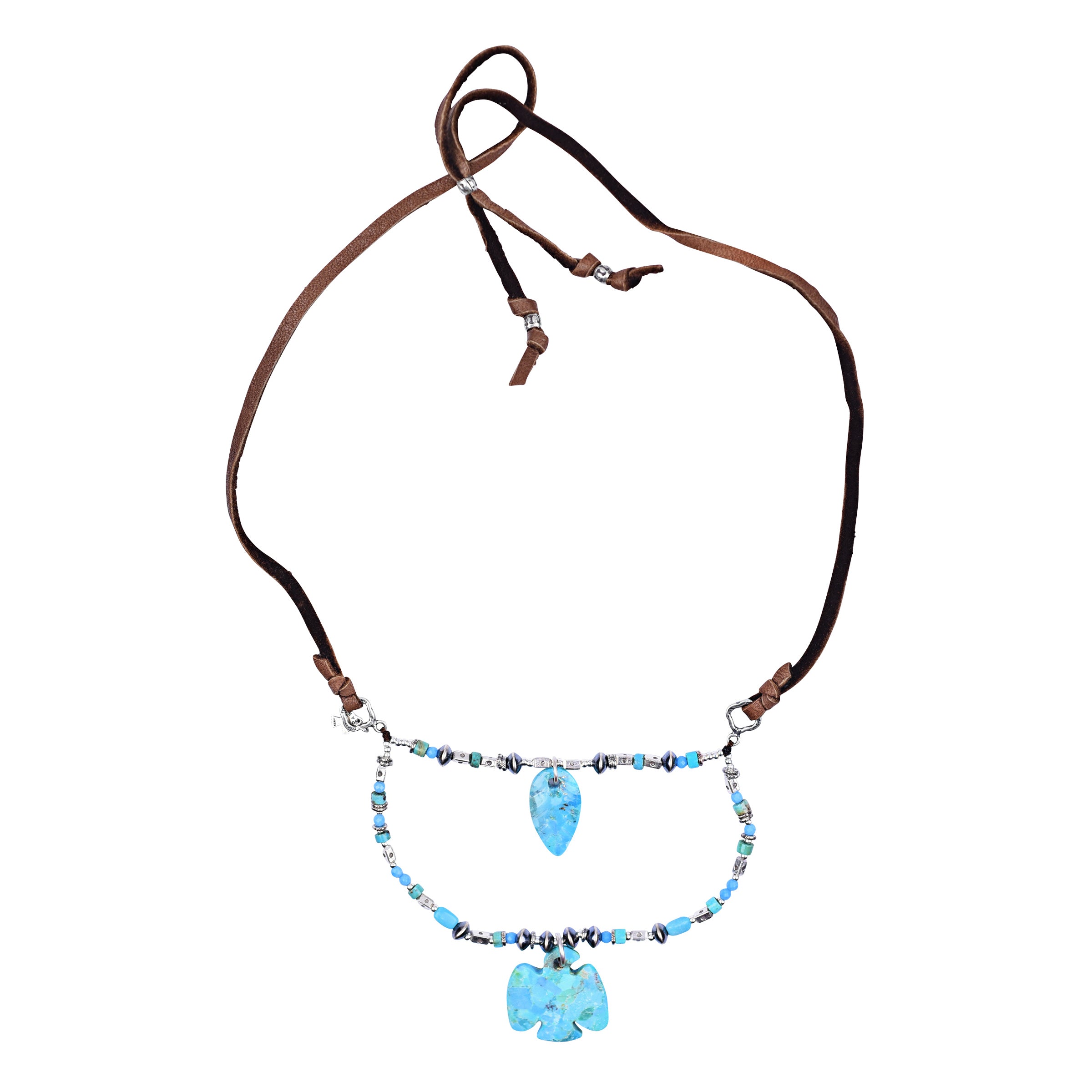 A boho multi-layered leather and sterling silver necklace featuring turquoise, thunderbird carving, and leaf carving