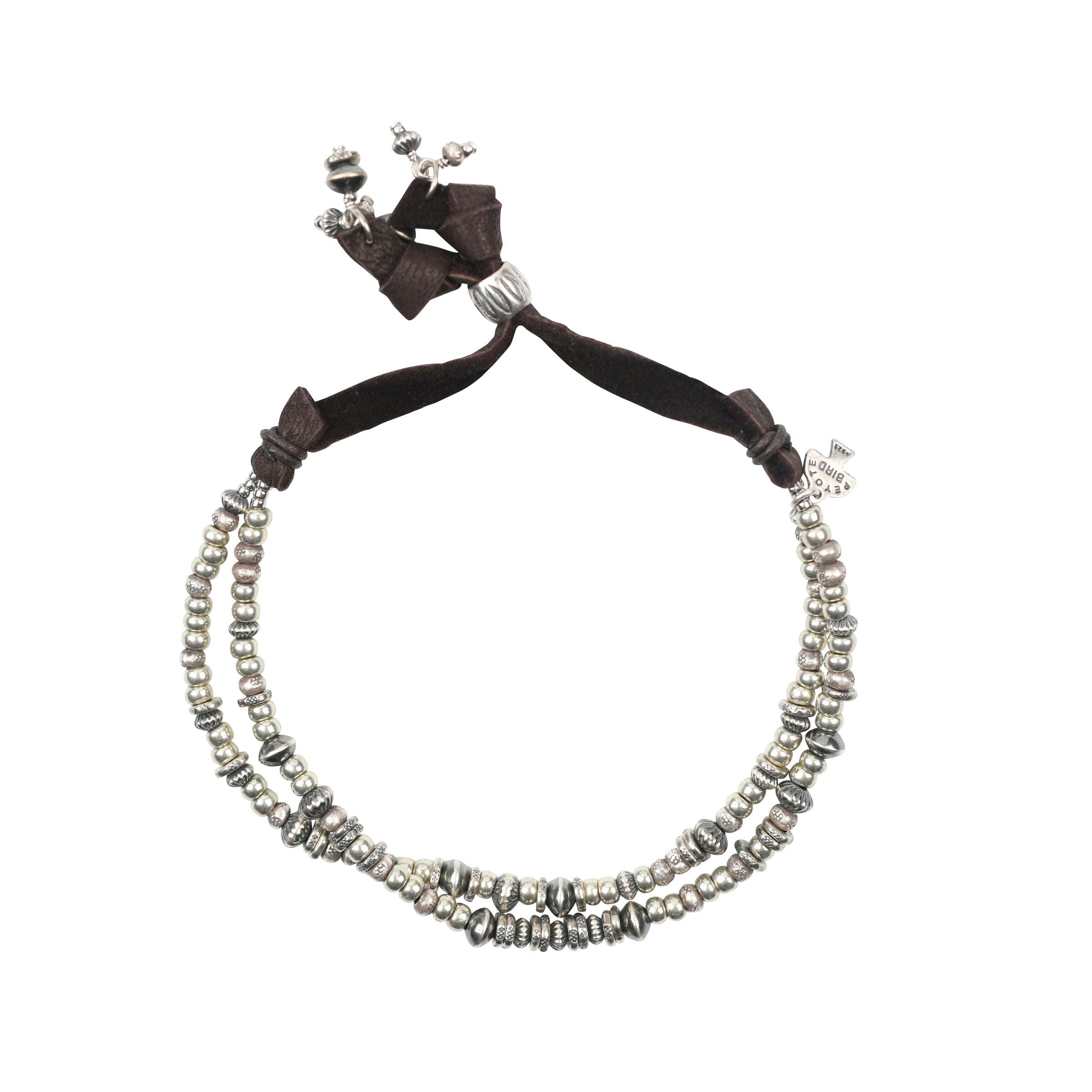 A double strand bracelet strung with Sterling Silver Thai Beading on soft, brown deerskin leather finished with a Sterling Silver slider bead for an adjustable fit.