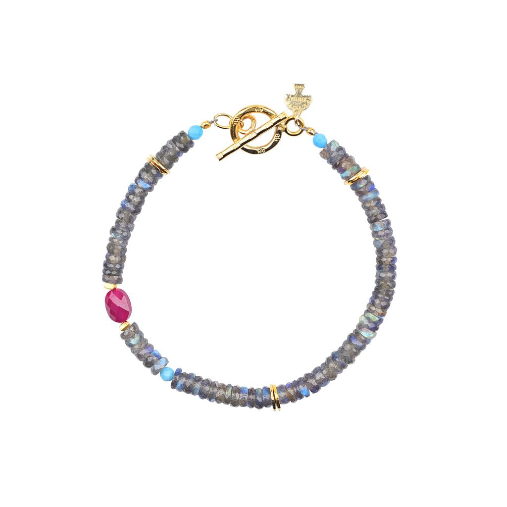 A gold plate beaded bracelet with labradorite, turquoise, and ruby stones featuring a toggle closure.