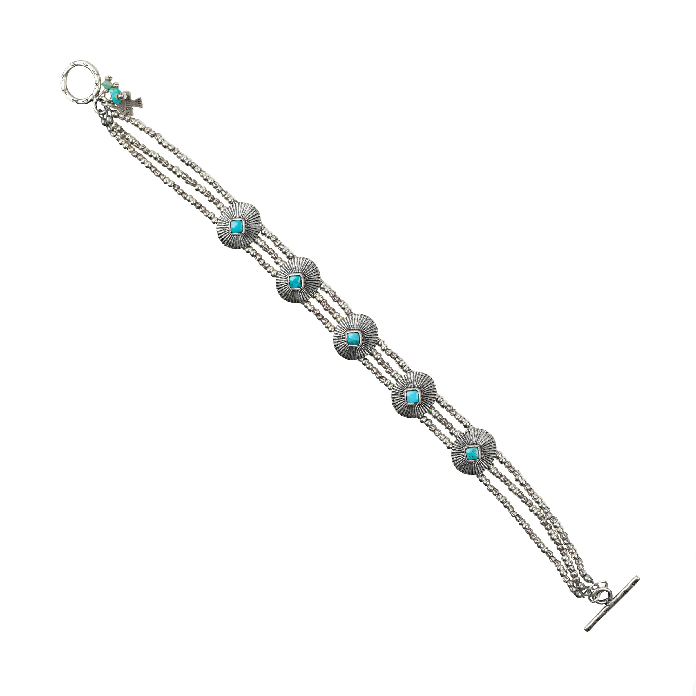 As seen in the Sundance Catalog, the Concho Bracelet is a multi-strand bracelet featuring five conchos adorned with diamond shapes of Blue Turquoise.