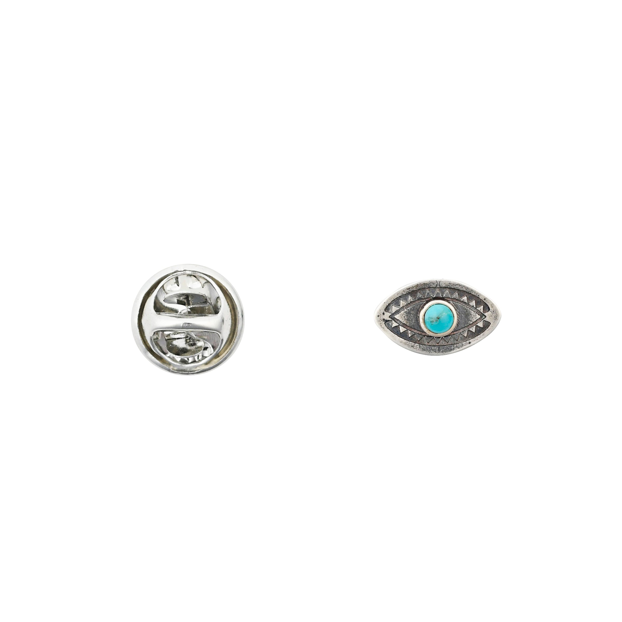 Sterling silver eye shaped pin with turquoise "iris" and stamping details next to pinback. 