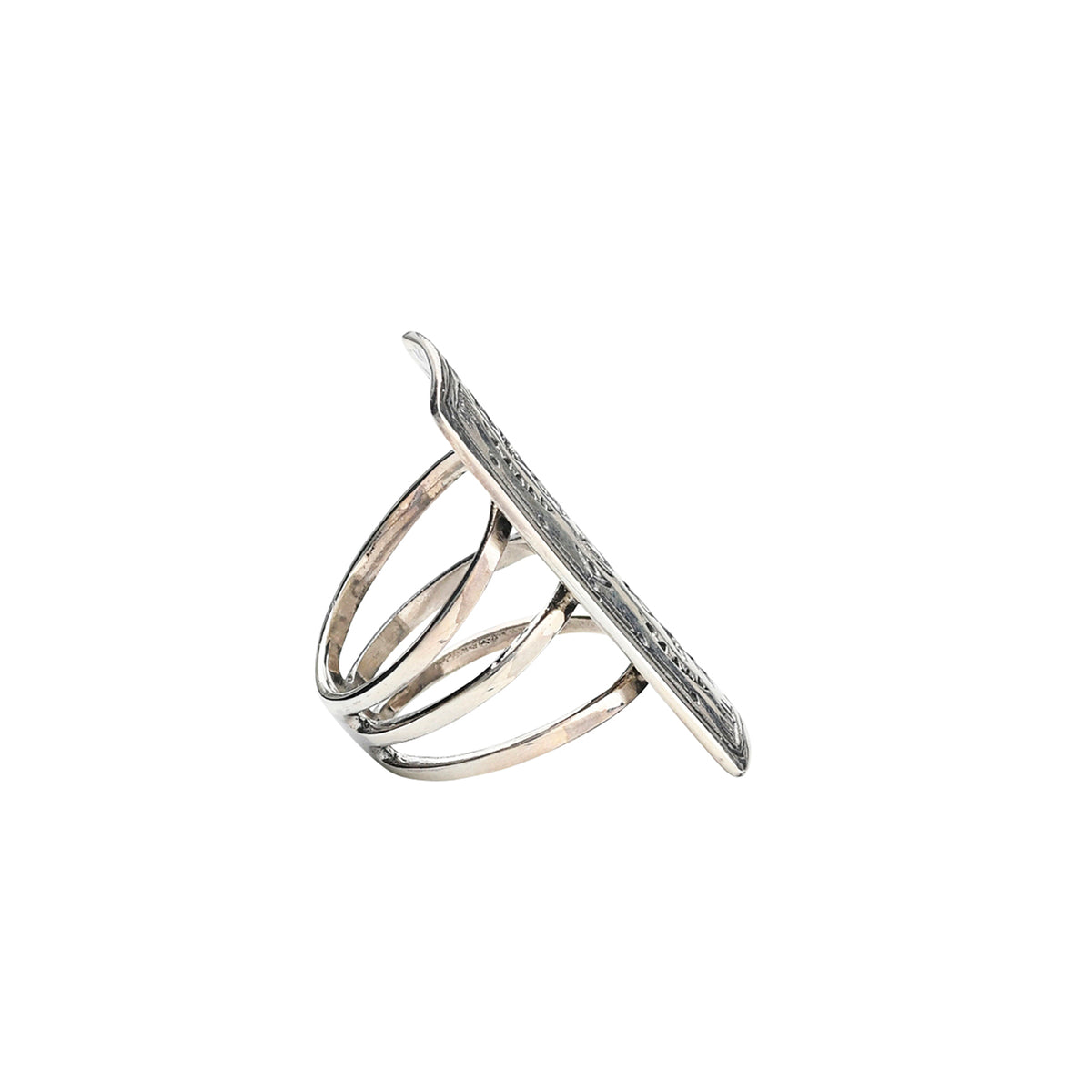 A sterling silver shield ring with intricate stamped arrows and hearts with geometric patterns and a split shank design.