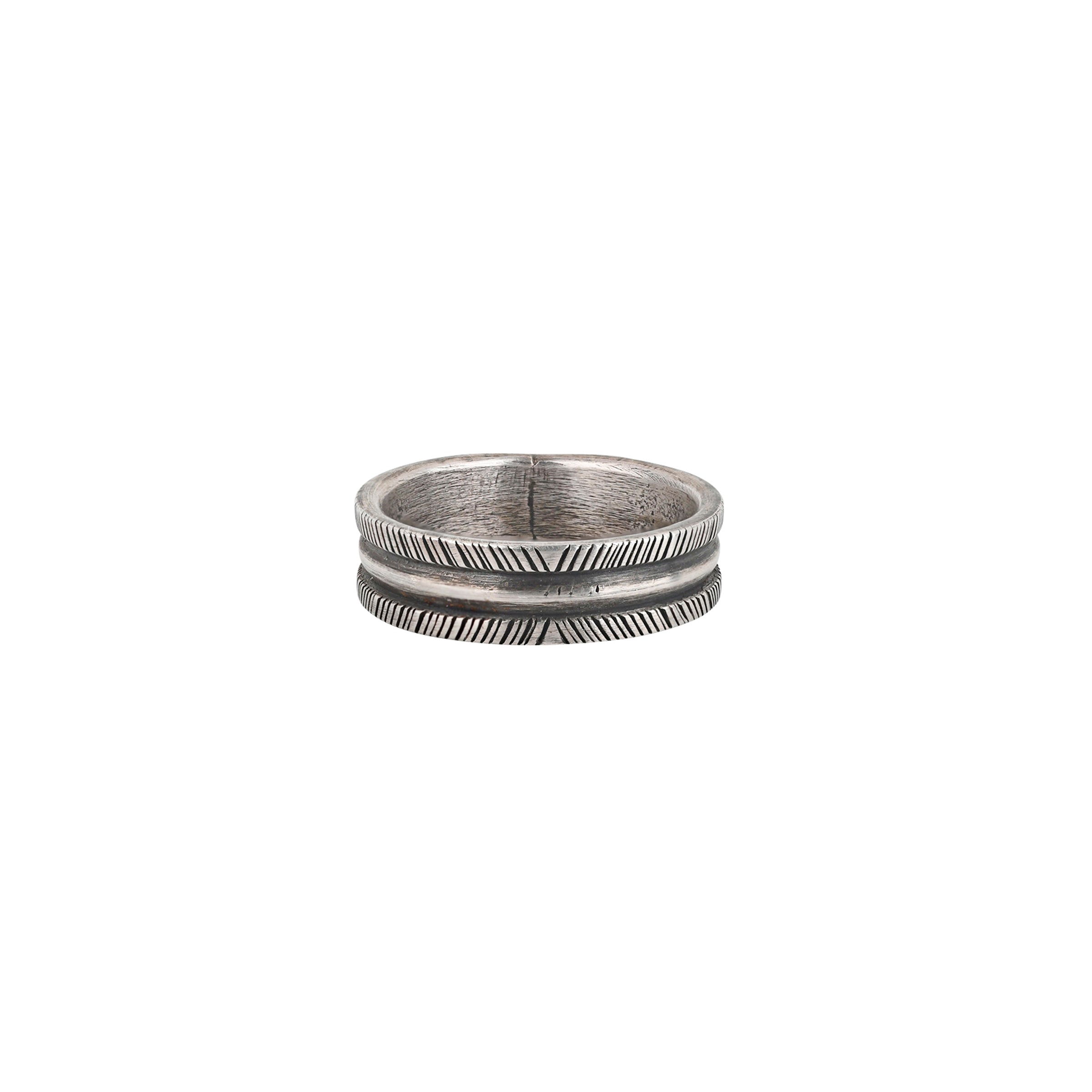The Ranchline Ring by Joey Falcon features a herringbone-like pattern with a smooth, raised ring of silver int he middle.