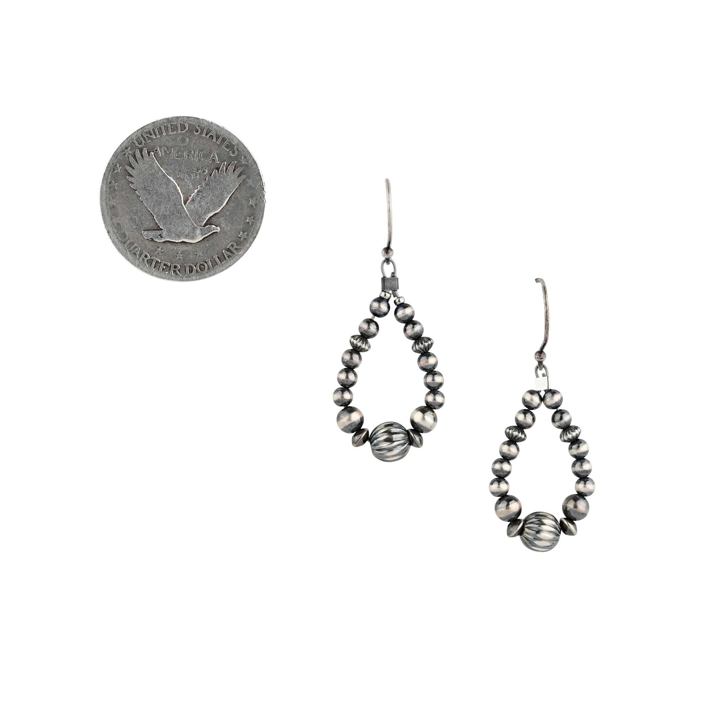 Hand-strung desert pearl hoop earrings next to coin for scale