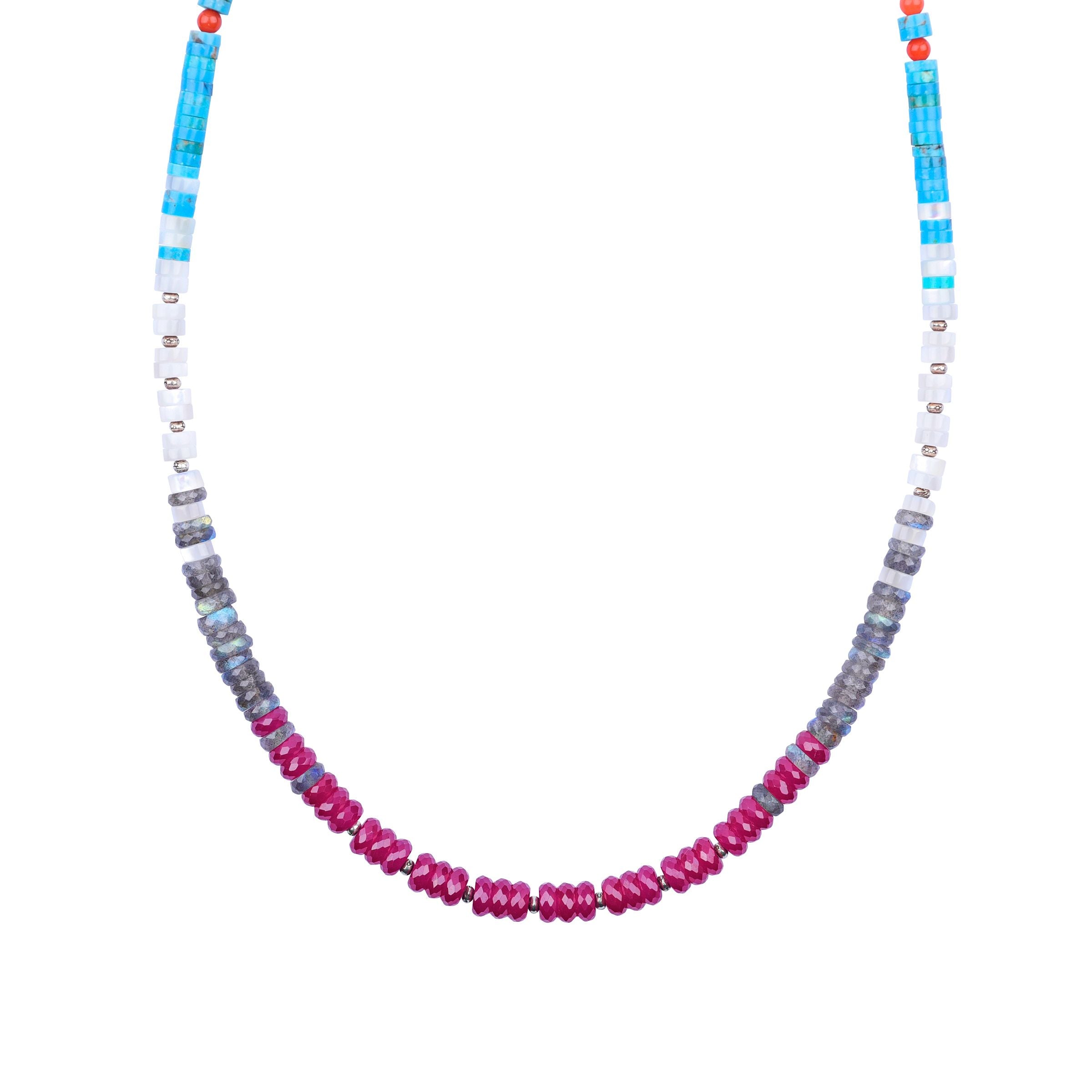 A multicolored beaded necklace with blue turquoise, orange coral, lapis, labradorite, mother of pearl, and ruby  beads, with a sterling silver chain.