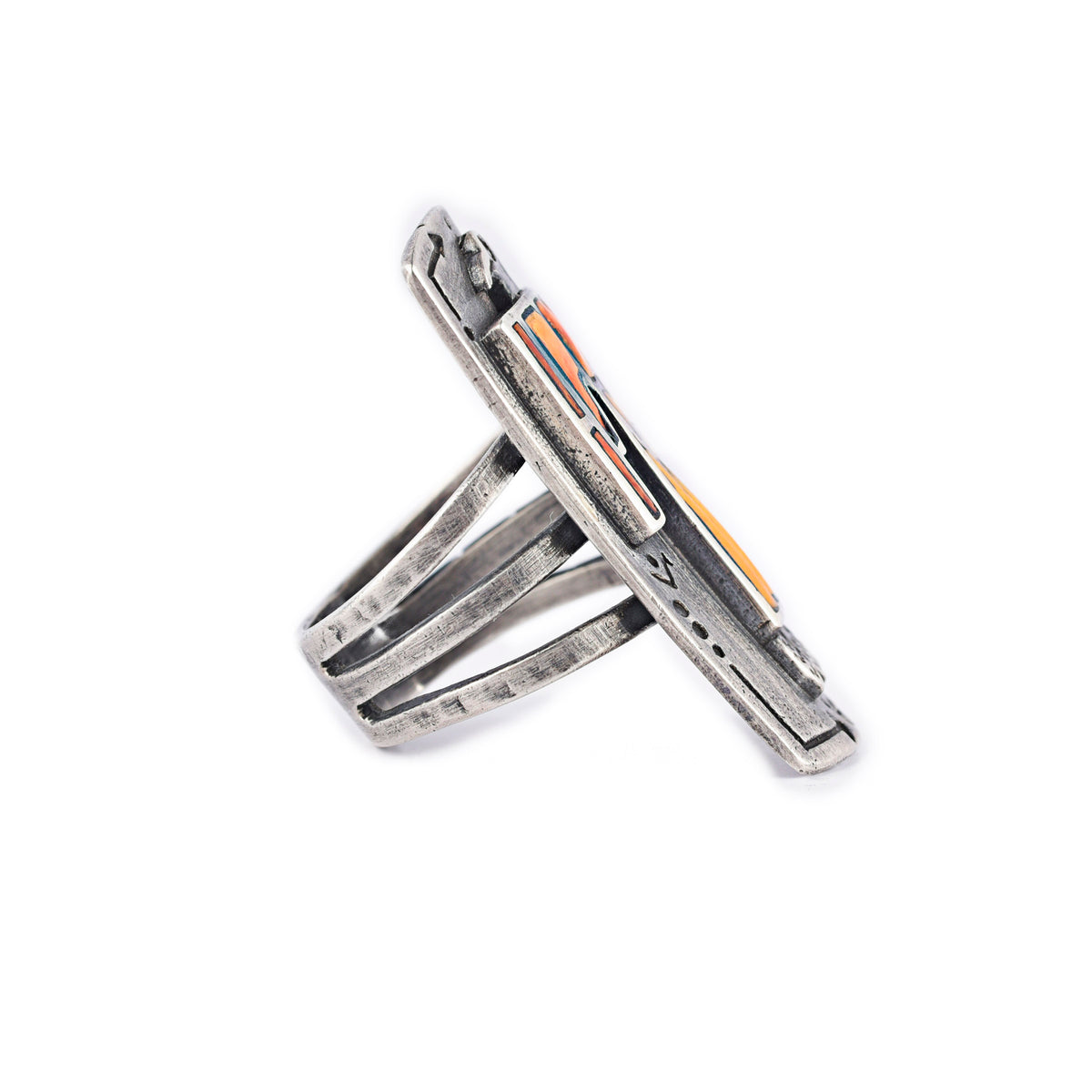 A sterling silver shield ring with spiny oyster shell stones inlayed into an intricate thunderbird design. Added stamping and the split shank design of the band make this ring exceptional. 